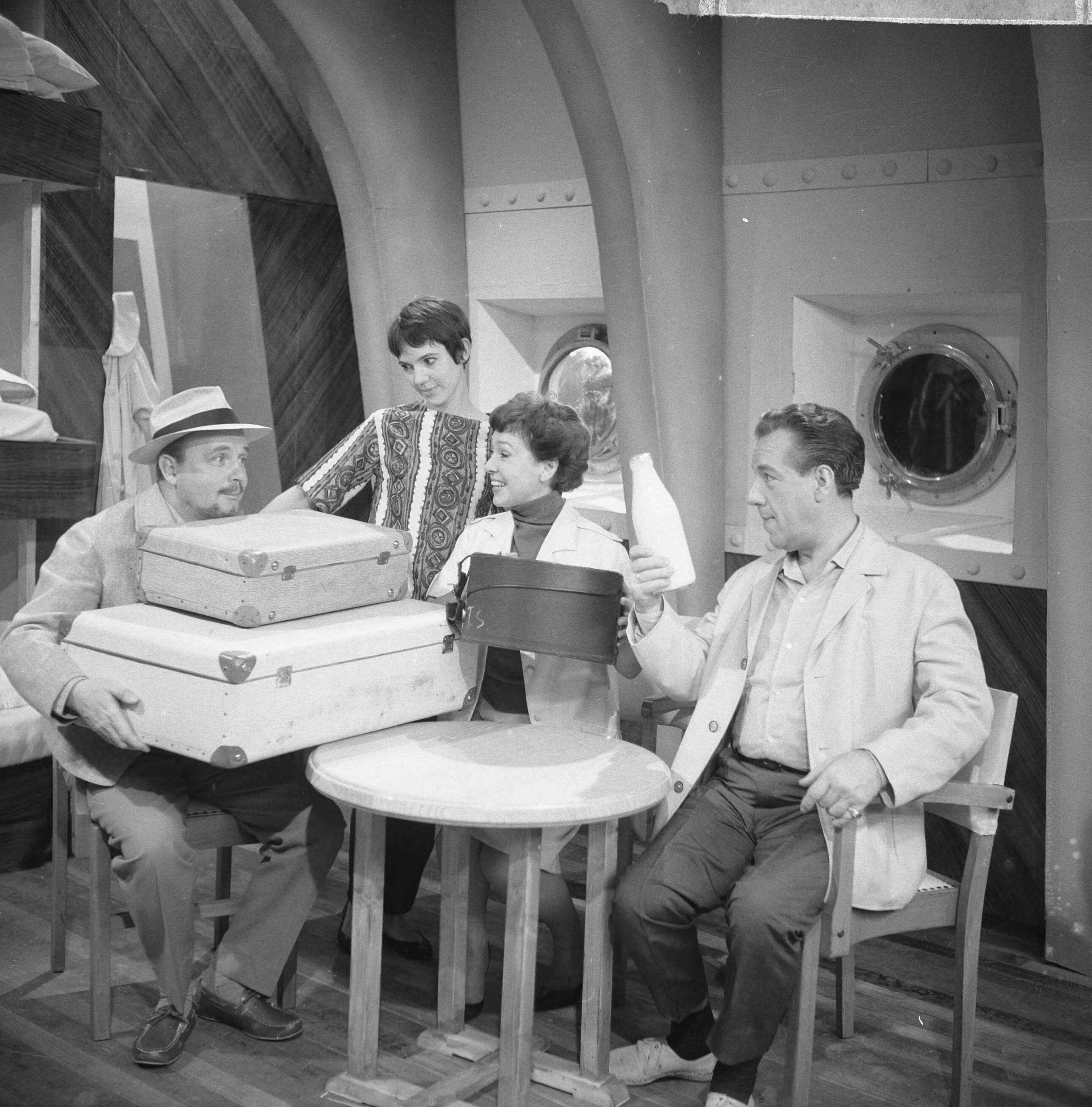 Fotocollectie Anefo — Opname televisiespel "Met 24 pk door Europa" (uitzending niet doorgegaan), vlnr. Guus Verstraete jr. , Simone Rooskens, Teddy Schaank en Ko van DijkNegatieven zijn een jaar later, op 31-3-1964, geregistreerd in fotoadministratie Anefo! Deze aflevering is wél uitgezonden, als eerste op 20-10-1963. Op 22-11-1963 schrijft Trouw: Er komen geen afleveringen meer van de televisiestrip "Met 24 P.K. door Europa" met Ko van Dijk, Teddy Schaank en Simone Rooskens. De AVRO heeft besloten de serie te staken. Reden: de strip kon ook na bewerking van het oorspronkelijke script niet aan de gestelde eisen voldoen. Karel Prior, hoofd amusementsprogramma's van de AVRO zei van deze door het echtpaar Mazure geschreven strip, dat ze „te filmisch" waren geschreven, waardoor men er in de televisiestudio's niet goed mee uit de voeten kon. Ellen en Georges Mazure, die zes afleveringen van hun strip aan de AVRO verkochten, liggen al een poosje overhoop met de AVRO in verband met de televis