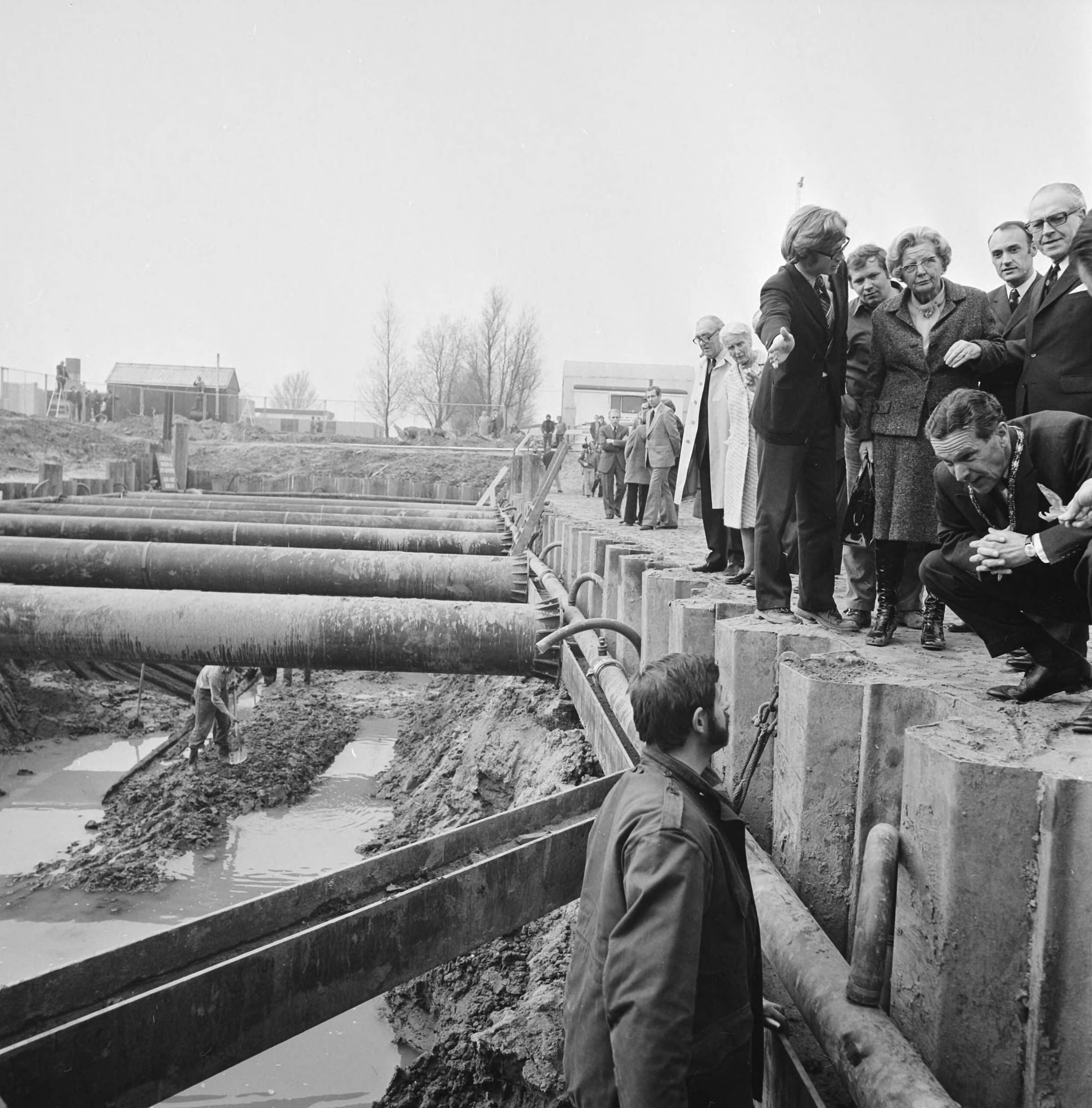 Fotocollectie Anefo — koningin Juliana bezoekt wrak Romeins schip in Zwammerdam; koningin Juliana kijkt over de rand in de kuil — Foto: Mieremet, Rob / Anefo. Licentie: Set B: Rechtenvrij / Publiek Domein. Bron: Nationaal Archief. http://hdl.handle.net/10648/ac4713aa-d0b4-102d-bcf8-003048976d84