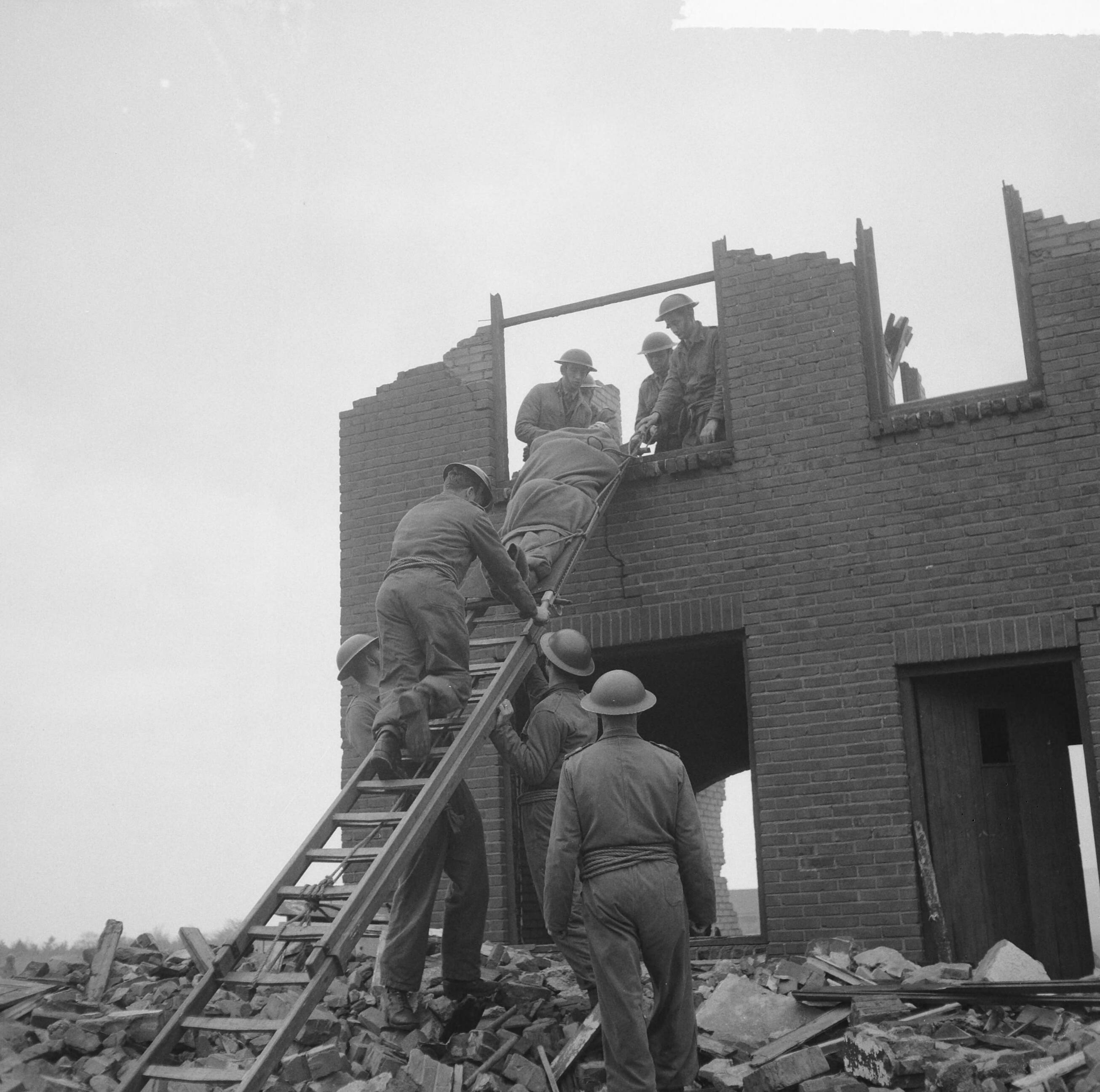 Fotocollectie Anefo — Oefening Korps Mobiele Colonnes in kamp Crailo bij Laren (N.H.), redding van gewonden uit huizen (opdracht Trouw) — Foto: Lindeboom, Henk / Anefo. Licentie: Set B: Rechtenvrij / Publiek Domein. Bron: Nationaal Archief. http://hdl.handle.net/10648/a9bdc0ca-d0b4-102d-bcf8-003048976d84