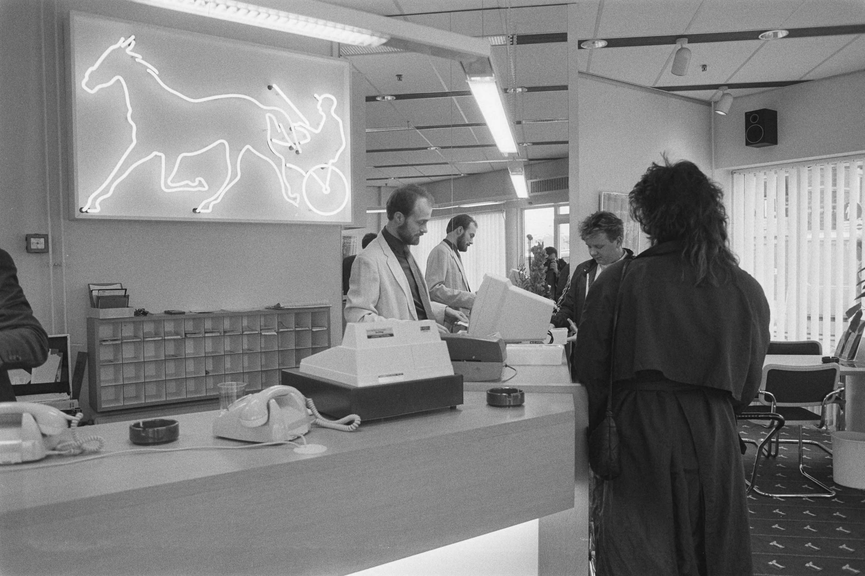 Fotocollectie Anefo — Eerste wedkantoor voor paardenkoersen van Ladbroke Totalisator geopend in Scheveningen — Foto: Croes, Rob C. / Anefo. Licentie: Set B: Rechtenvrij / Publiek Domein. Bron: Nationaal Archief. http://hdl.handle.net/10648/ad5cc6ae-d0b4-102d-bcf8-003048976d84