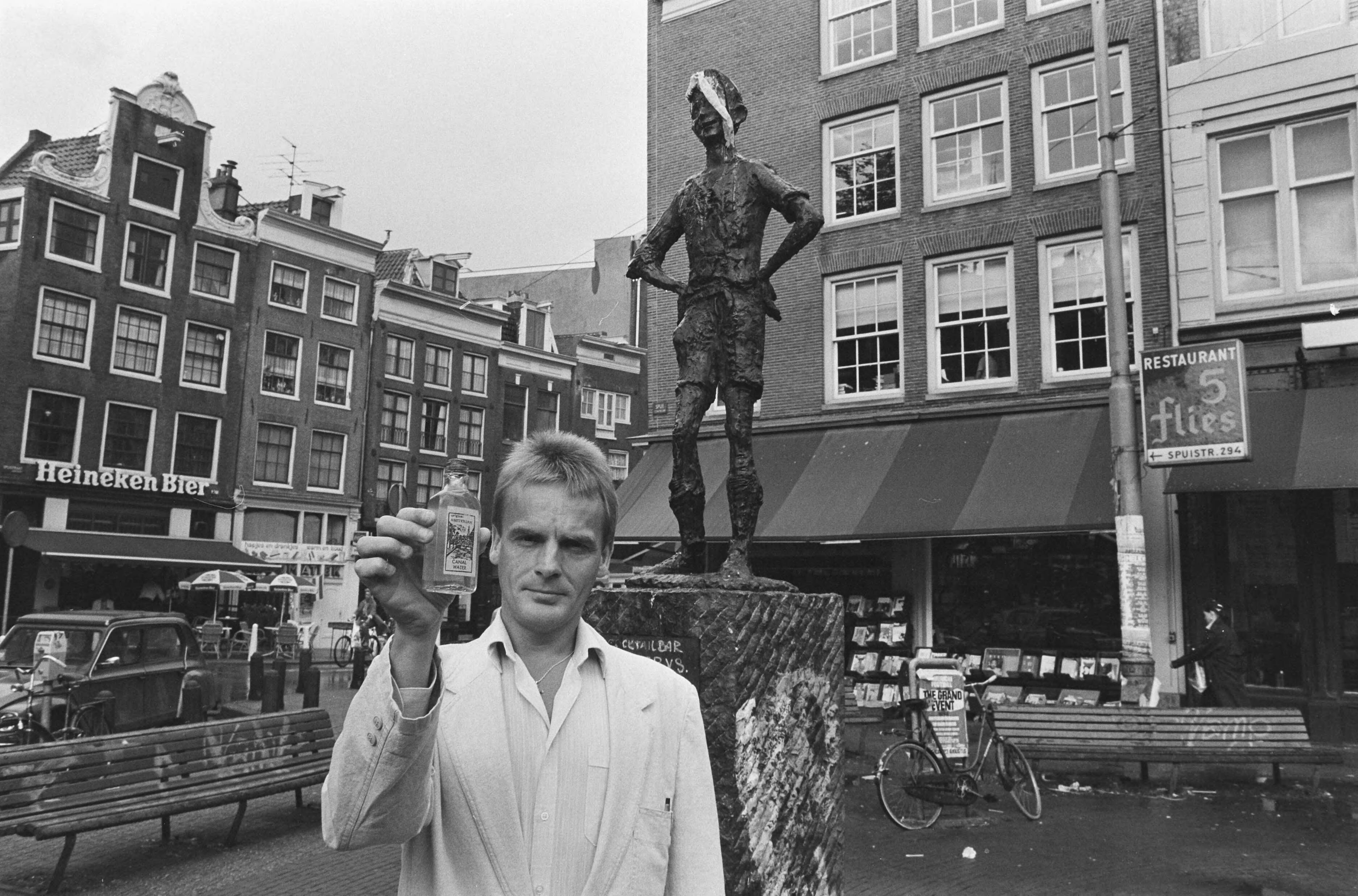 Fotocollectie Anefo — Opdracht Utrechts Nieuwsblad; Rob Elson met Grachtwater bij Lieverdje — Foto: Gerrits, Roland / Anefo. Licentie: Set B: Rechtenvrij / Publiek Domein. Bron: Nationaal Archief. http://hdl.handle.net/10648/ad568a1e-d0b4-102d-bcf8-003048976d84