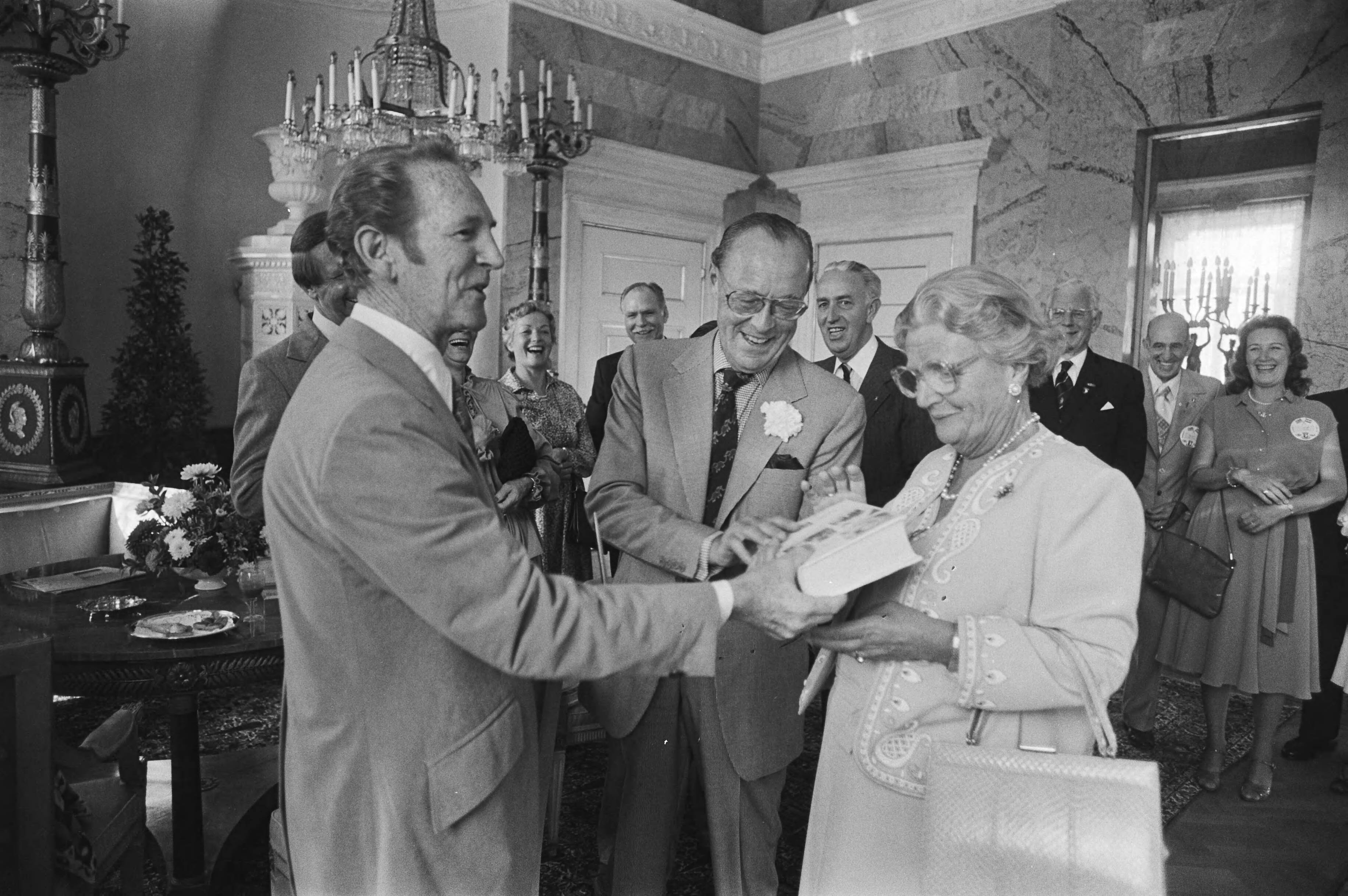 Boek over de 101e Airborne Division door oudstrijders aan koningin Juliana aangeboden op Paleis Soestdijk — De president van de 101st Airborne Division Association, Weldon Combs, overhandigt een boek over deze divisie aan koningin Juliana, terwijl prins Bernhard toekijkt — Foto: Suyk, Koen / Anefo. Licentie: Set B: Rechtenvrij / Publiek Domein. Bron: Nationaal Archief. http://hdl.handle.net/10648/acd14fc0-d0b4-102d-bcf8-003048976d84