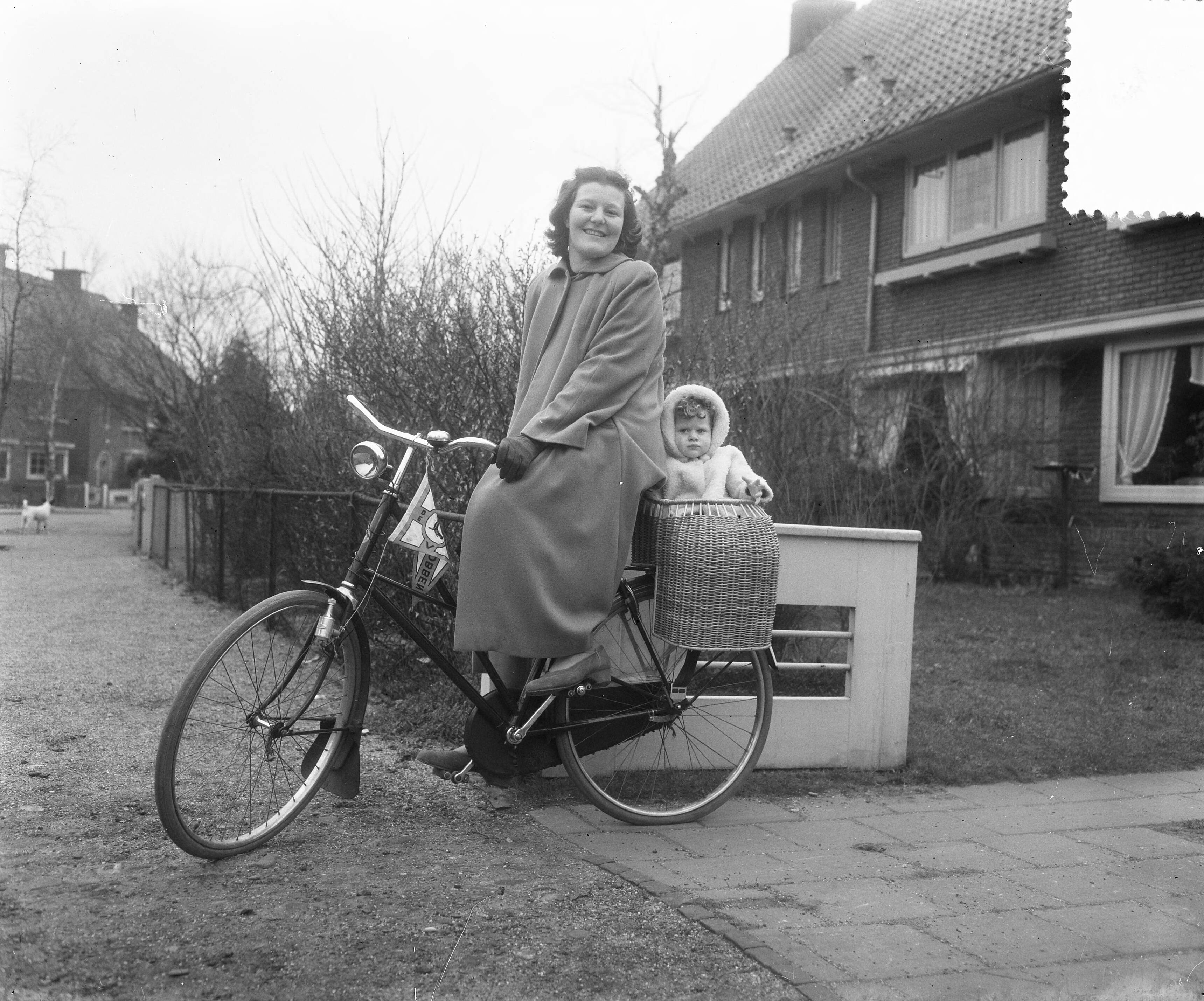 Reportage zwemster Nel Koudijs-Van Vliet — Reportage zwemster Nel Koudijs-Van Vliet. Nel van Vliet op de fiets met een dochter in een kinderzitje — Foto: Duinen, H. van / Anefo. Licentie: Set B: Rechtenvrij / Publiek Domein. Bron: Nationaal Archief. http://hdl.handle.net/10648/a8f6eaa4-d0b4-102d-bcf8-003048976d84
