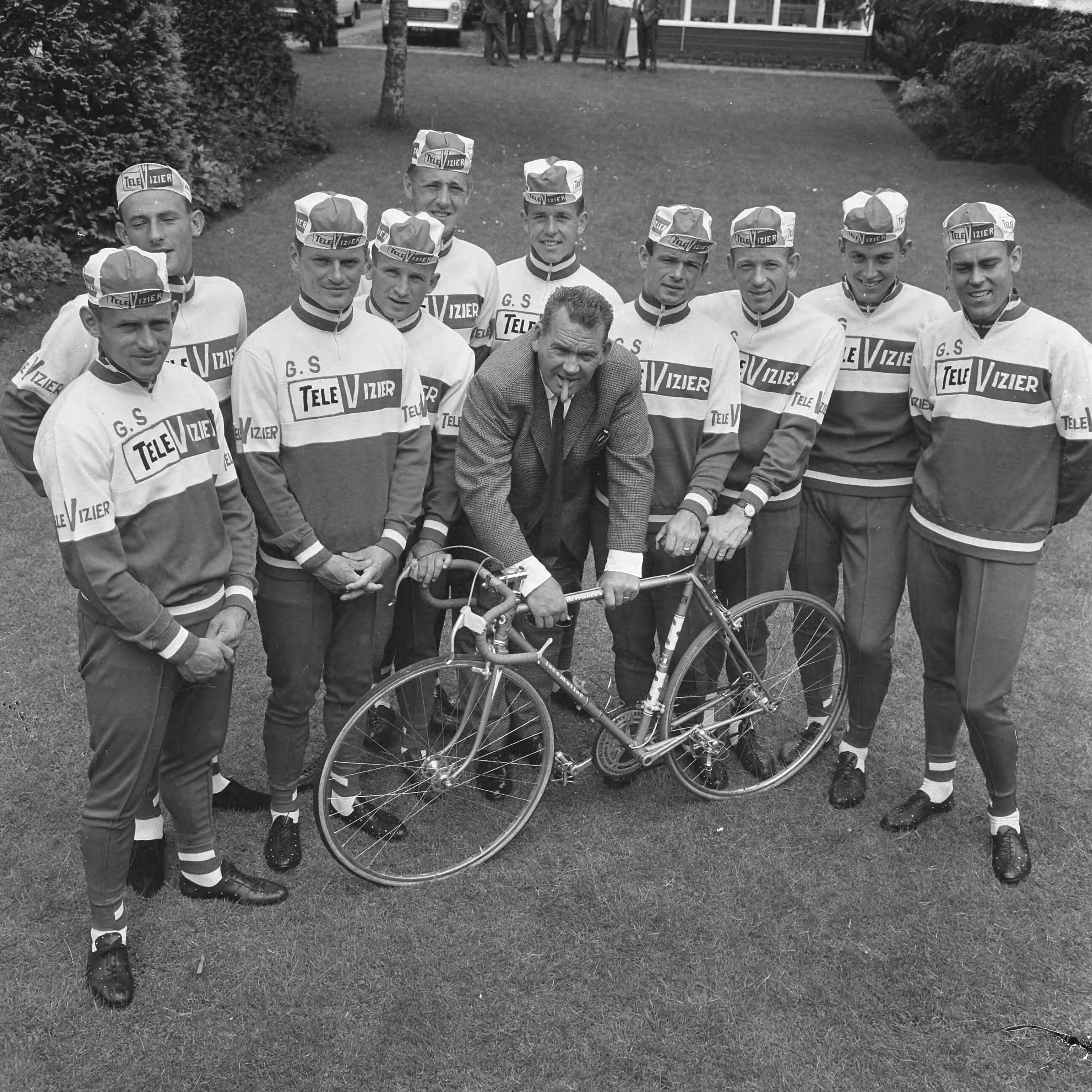 Fotocollectie Anefo — Televizierploeg voor de Tour de France in Hotel De Zwaan te Etten voorgesteld, Kees Pellenaars met zijn Televizier- Tourploeg. Gegroepeerd rond „de Pel" v.l.n.r. Nijdam, Wouters, de Haan. Harings, van Espen, van Dongen. Haast Maliepaard, Karstens en de Roo. — Foto: Evers, Joost / Anefo. Licentie: Set B: Rechtenvrij / Publiek Domein. Bron: Nationaal Archief. http://hdl.handle.net/10648/aaadb3be-d0b4-102d-bcf8-003048976d84