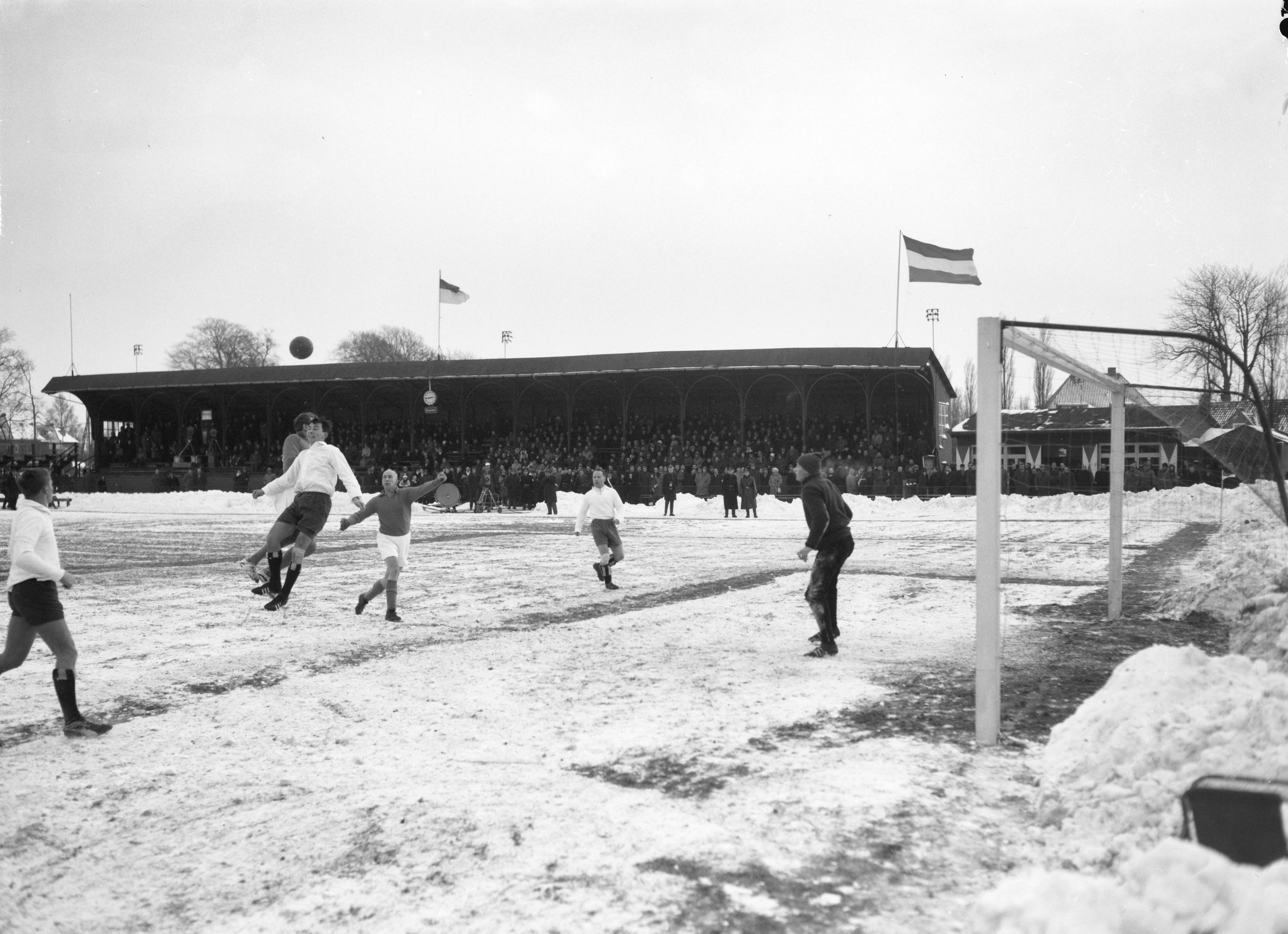 Fotocollectie Anefo — Traditionele nieuwjaars voetbalwedstrijd tussen de Koninklijke HFC en Oud-Internationals 2-8. Spelmoment voor het HFC-doel, in het midden Wim Roosen, koppend [waarschijnlijk] Piet Groeneveld. Rechts HFC-keeper Guus van der Meulen jr. — Foto: Bilsen, Joop van / Anefo. Licentie: Set B: Rechtenvrij / Publiek Domein. Bron: Nationaal Archief. http://hdl.handle.net/10648/aa24642e-d0b4-102d-bcf8-003048976d84
