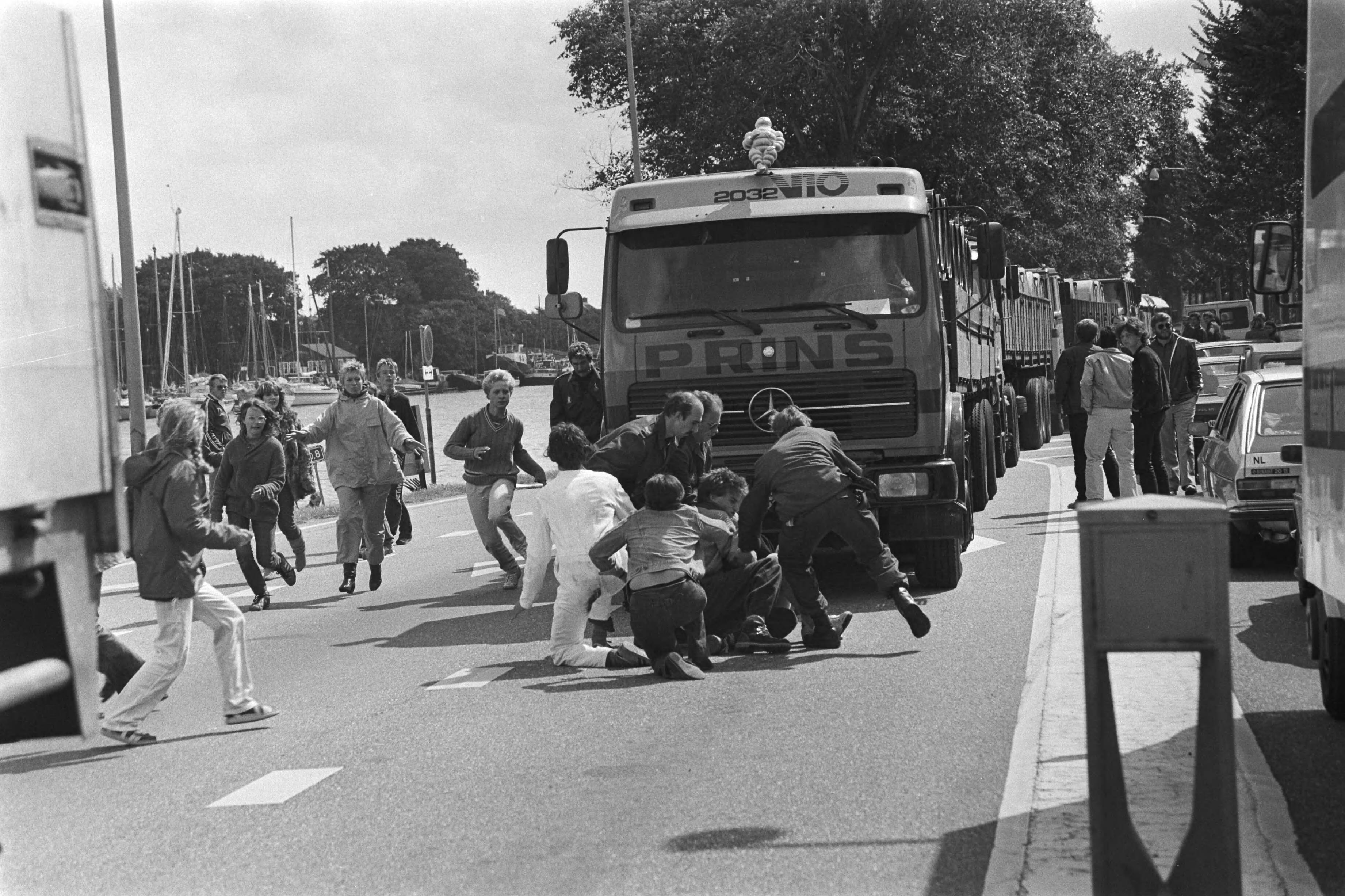Fotocollectie Anefo — Akties tegen transport radioactief afval van Petten naar Den Helder ; aktievoerders springen voor de aanrijdende autos, ME-ers grijpen in — Foto: Dijk, Hans van / Anefo. Licentie: Set B: Rechtenvrij / Publiek Domein. Bron: Nationaal Archief. http://hdl.handle.net/10648/ad1ce944-d0b4-102d-bcf8-003048976d84