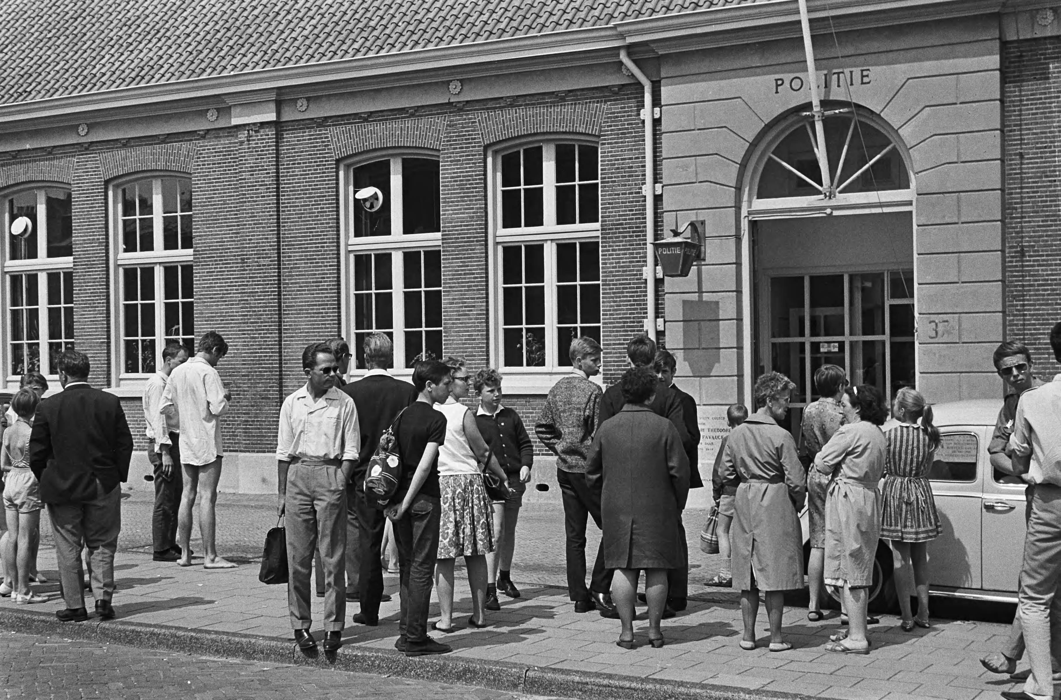 Fotocollectie Anefo — Colin Chapman, de manager van [autocoureur] Jim Clark, die door de Zandvoortse politie was gearresteerd, is door de Officier van Justitie te Haarlem vrijgelaten, op voorwaarde dat hij op 20 juli zal verschijnen voor de politierechter. Publiek bij het politiebureau van Zandvoort — Foto: Evers, Joost / Anefo. Licentie: Set B: Rechtenvrij / Publiek Domein. Bron: Nationaal Archief. http://hdl.handle.net/10648/aab51d16-d0b4-102d-bcf8-003048976d84