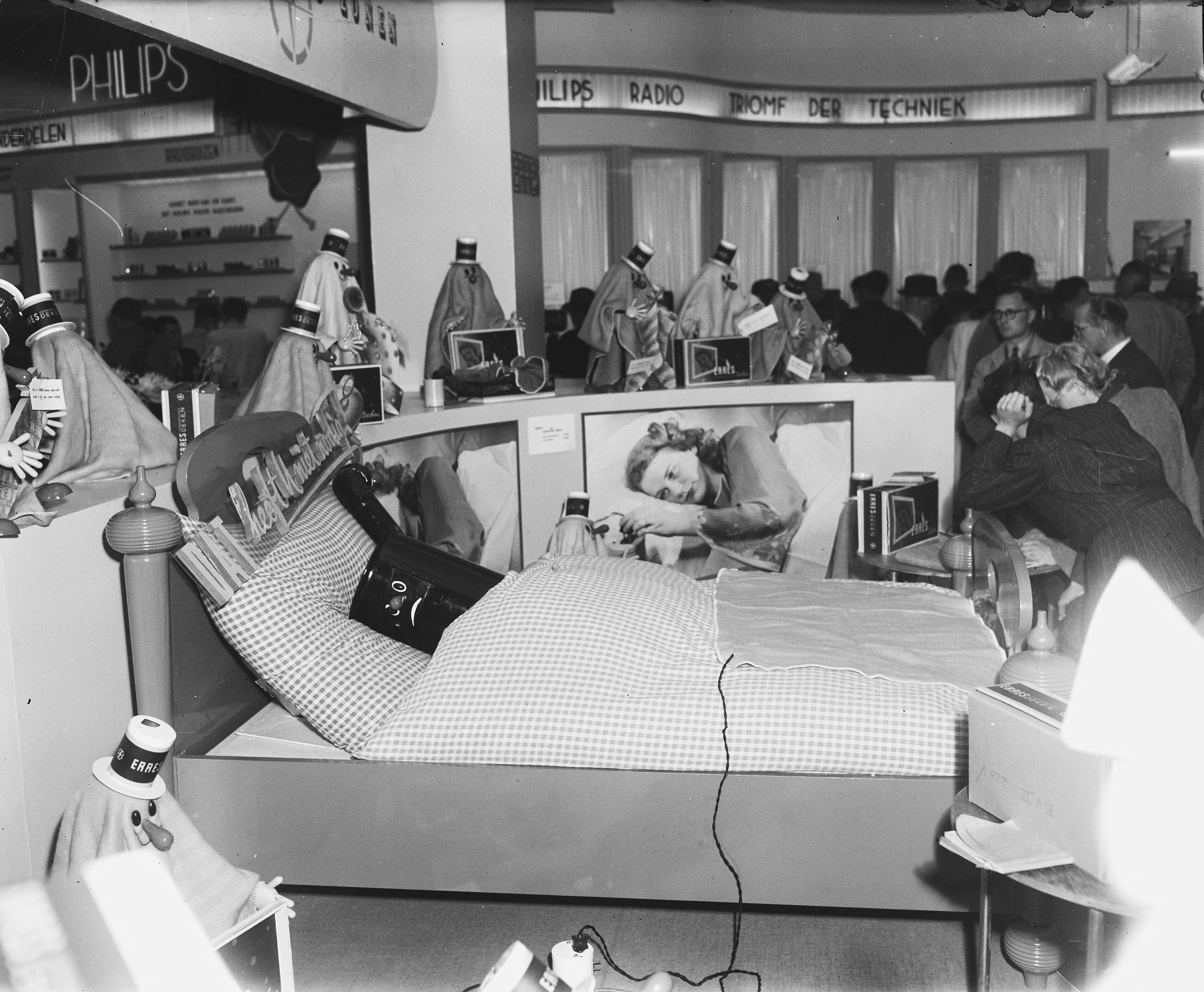 Fotocollectie Anefo — Jaarbeurs te Utrecht. Kachel in bed — Foto: Merk, Ben / Anefo. Licentie: Set B: Rechtenvrij / Publiek Domein. Bron: Nationaal Archief. http://hdl.handle.net/10648/a8bce476-d0b4-102d-bcf8-003048976d84