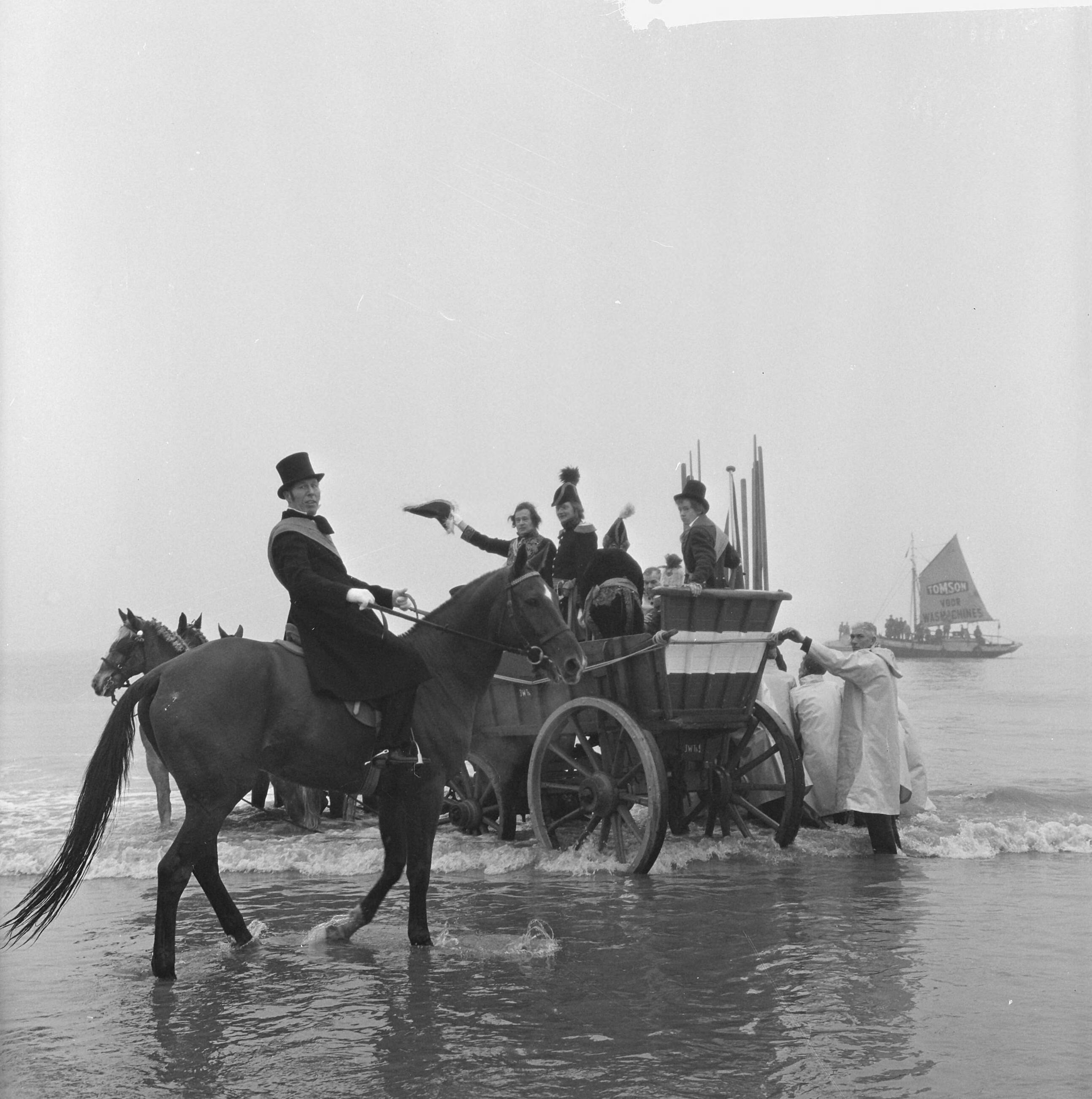 Fotocollectie Anefo — Te Scheveningen is de landing en intocht van prins Willem Frederik in 1813 herdacht. In de branding neemt de prins plaats in een nettenwagen. In de voorgrond met sjerp het historisch personage Jacob Pronk — Foto: Walta, Winfried / Anefo. Licentie: Set B: Rechtenvrij / Publiek Domein. Bron: Nationaal Archief. http://hdl.handle.net/10648/aa50071e-d0b4-102d-bcf8-003048976d84
