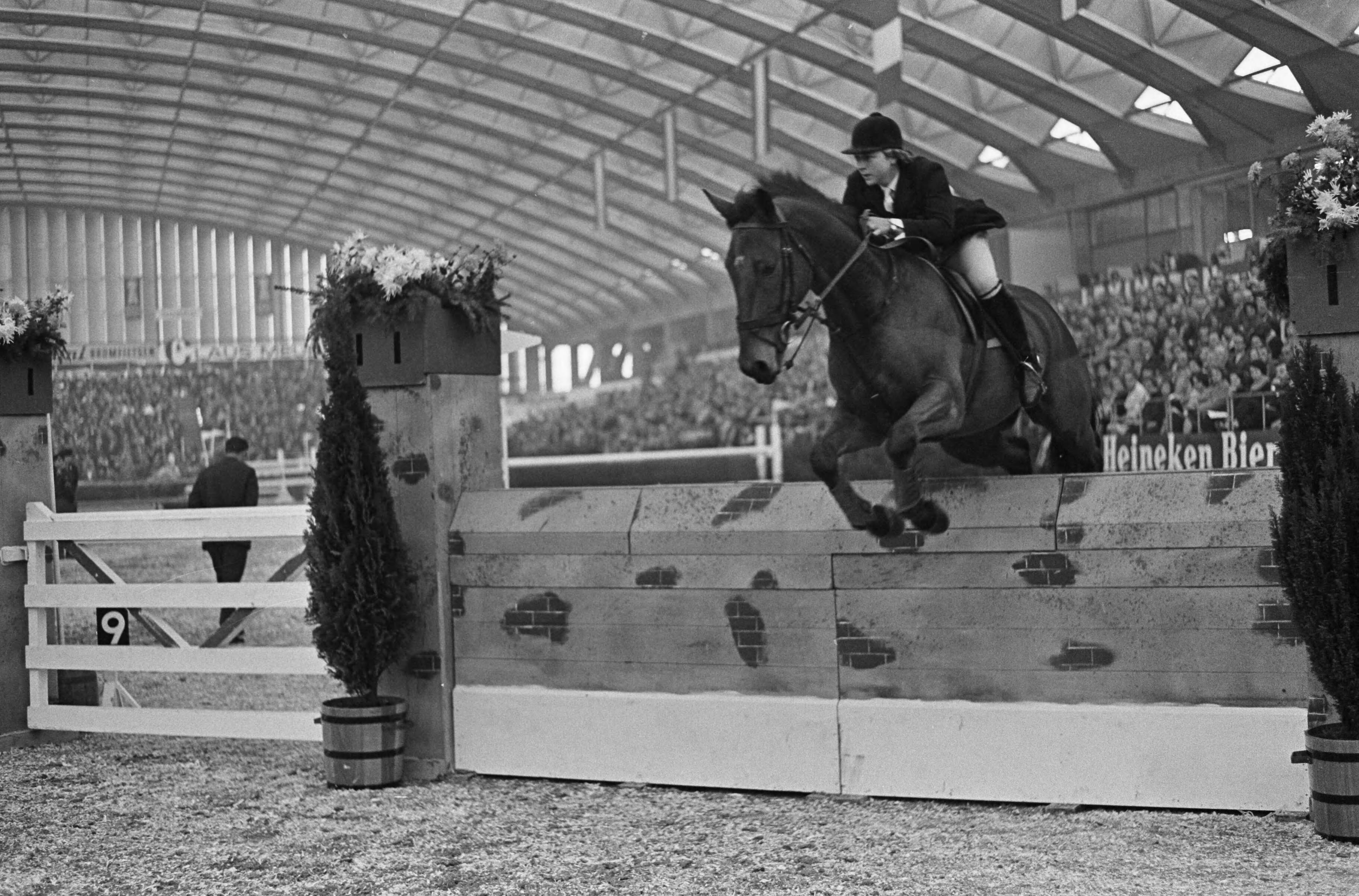 Jumping Amsterdam 1965 in de RAI te Amsterdam — De 18-jarige Britse amazone Marion Coakes tijdens sprong op het paard "Little Fellow" [tijdens Grote Prijs van Nederland — Foto: Fotograaf Onbekend / Anefo. Licentie: Set B: Rechtenvrij / Publiek Domein. Bron: Nationaal Archief. http://hdl.handle.net/10648/aac92338-d0b4-102d-bcf8-003048976d84