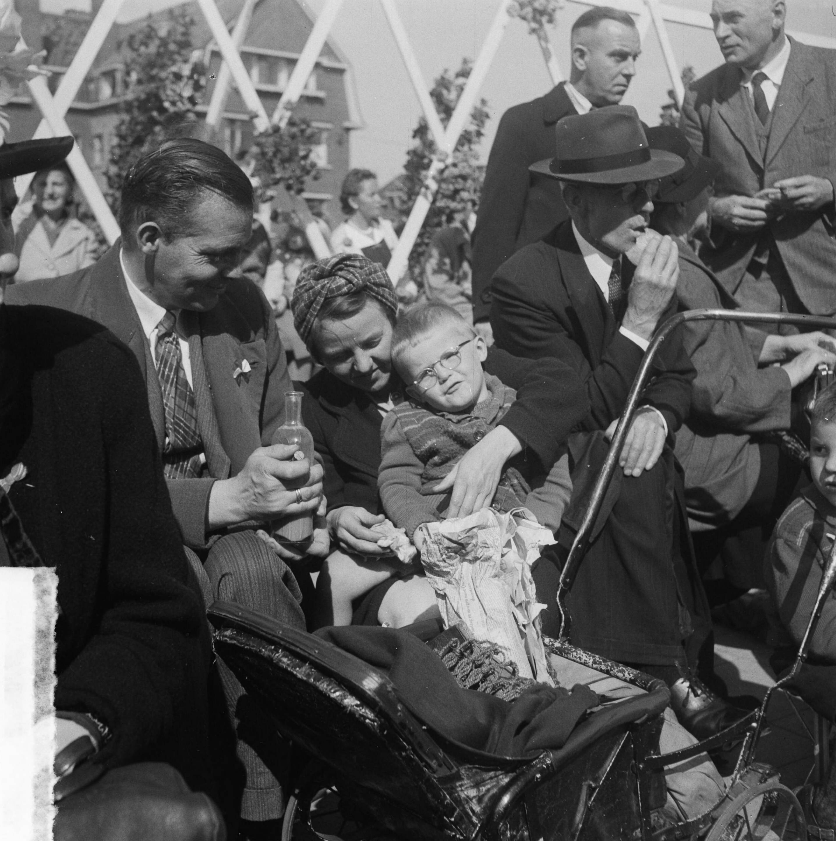 Intocht van koningin Juliana in Den Haag (1948) — Intocht Koningin Juliana in Den Haag. Gezin met kinderwagen langs de kant — Foto: Steenkamp, B.J.J. (Ben) / Anefo. Licentie: Set B: Rechtenvrij / Publiek Domein. Bron: Nationaal Archief. http://hdl.handle.net/10648/a8bd4470-d0b4-102d-bcf8-003048976d84