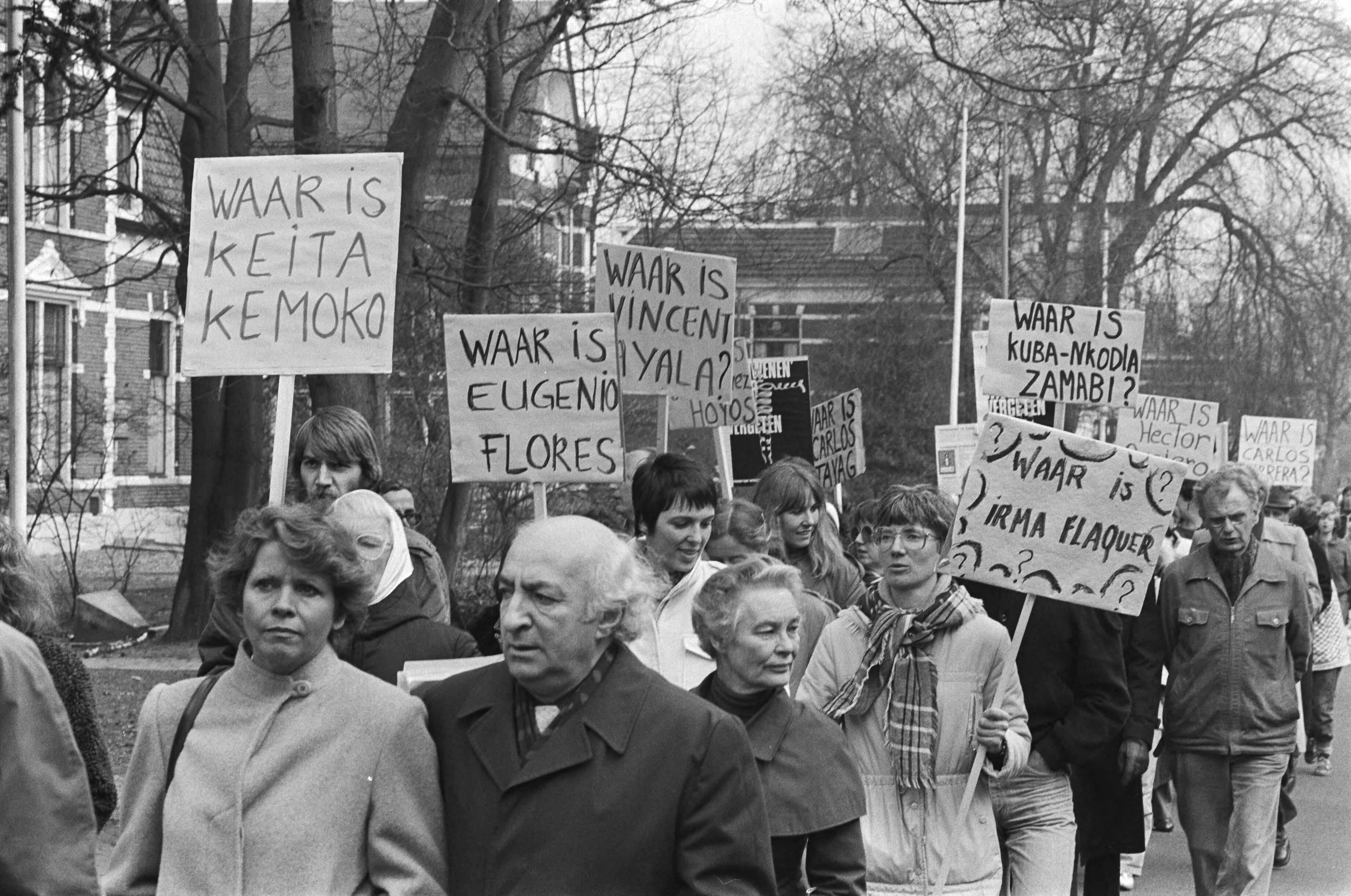 Fotocollectie Anefo — Demonstratie in Hilversum tegen verdwijningen. De demonstranten met borden met namen van verdwenen mensen — Foto: Antonisse, Marcel / Anefo. Licentie: Set B: Rechtenvrij / Publiek Domein. Bron: Nationaal Archief. http://hdl.handle.net/10648/ad130f46-d0b4-102d-bcf8-003048976d84