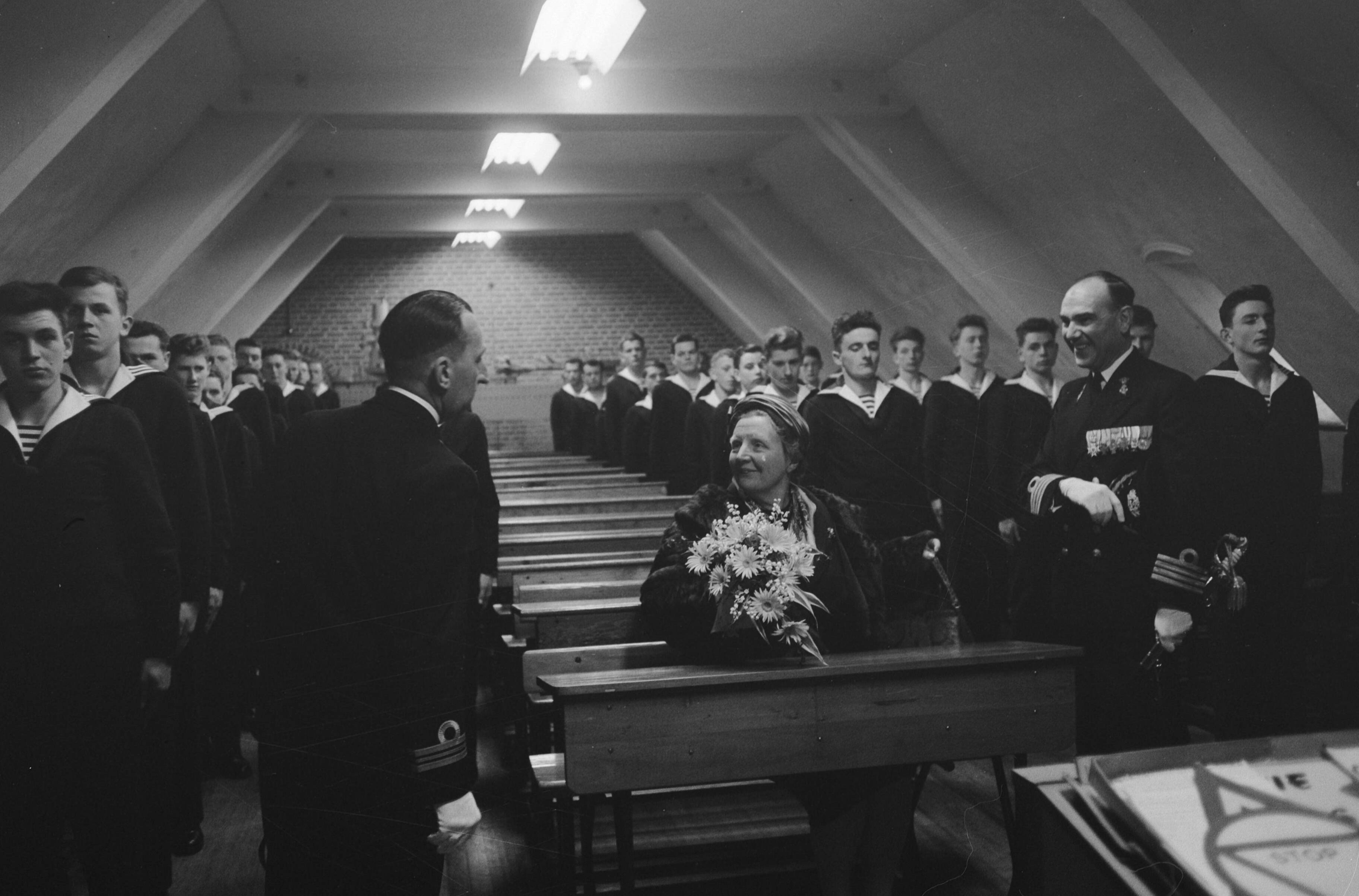 Fotocollectie Anefo — Koningin Juliana bezoekt marinekamp Loosdrecht. De koningin volgt een les over het verkeer in een schoolbank met rechts naast haar de commandant van het opleidingscentrum kapitein-ter-zee H.J. Baay — Foto: Pot, Harry / Anefo. Licentie: Set B: Rechtenvrij / Publiek Domein. Bron: Nationaal Archief. http://hdl.handle.net/10648/a9ce3784-d0b4-102d-bcf8-003048976d84