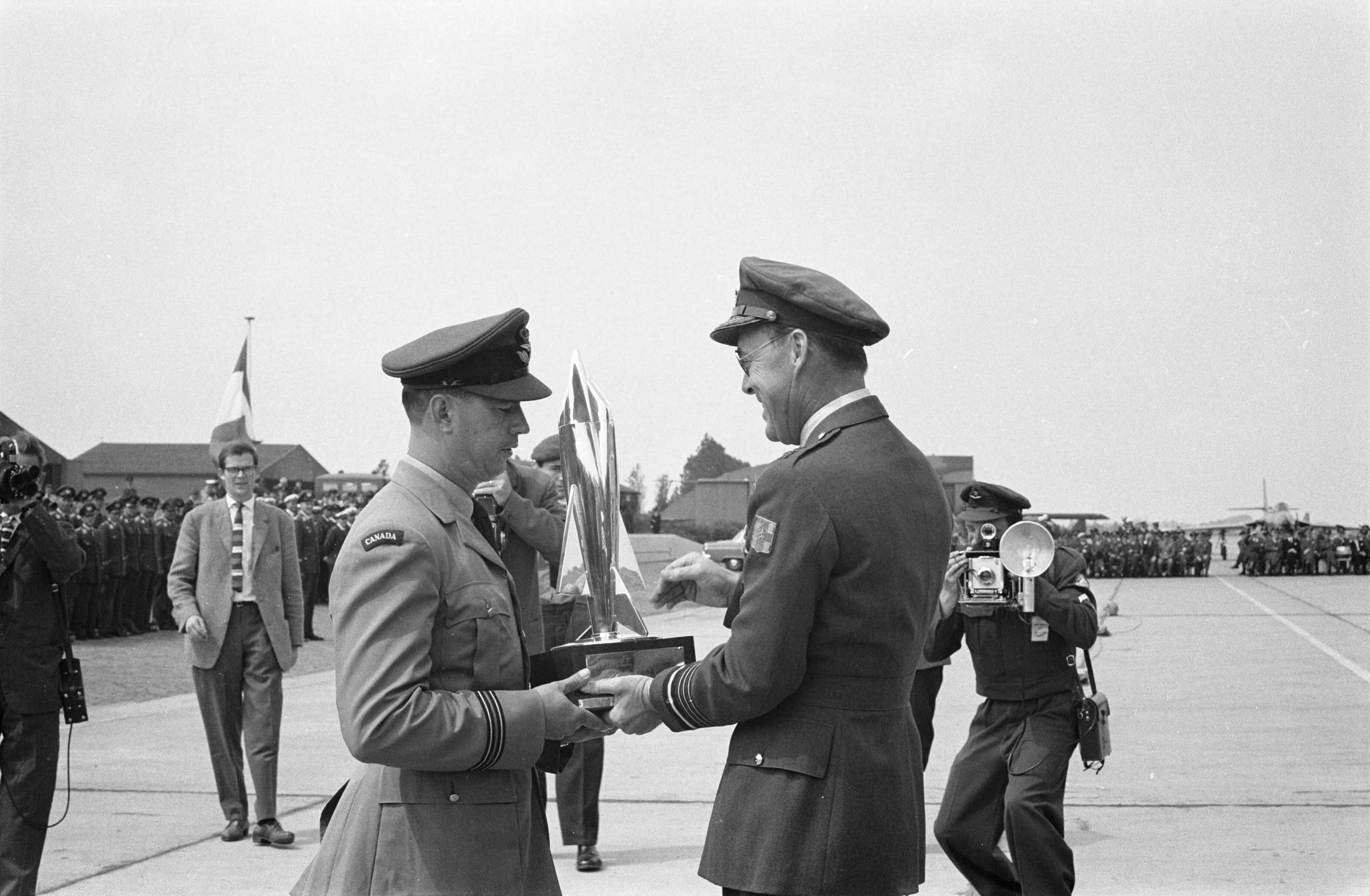 Fotocollectie Anefo — Prins Bernhard bij schietcompetitie NATO-Luchtmacht op vliegbasis Leeuwarden. Hij reikt de eerste prijs uit aan capt. Spencer van de Canadese luchtmacht — Foto: Rossem, Wim van / Anefo. Licentie: Set B: Rechtenvrij / Publiek Domein. Bron: Nationaal Archief. http://hdl.handle.net/10648/a9dbe24e-d0b4-102d-bcf8-003048976d84