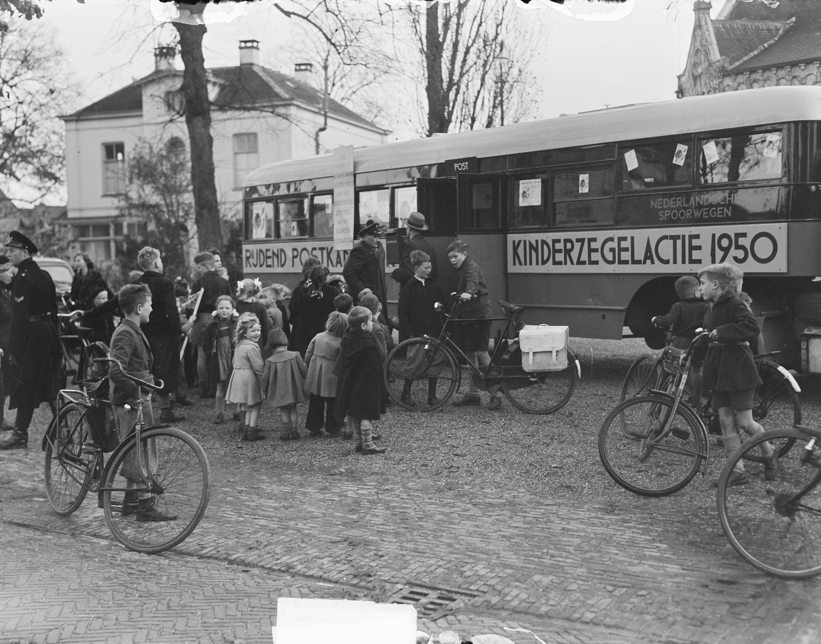 Fotocollectie Anefo — Rijdend postkantoor "Voor het Kind"in Baarn — Foto: Oorschot, […] van / Anefo. Licentie: Set B: Rechtenvrij / Publiek Domein. Bron: Nationaal Archief. http://hdl.handle.net/10648/a8e22628-d0b4-102d-bcf8-003048976d84