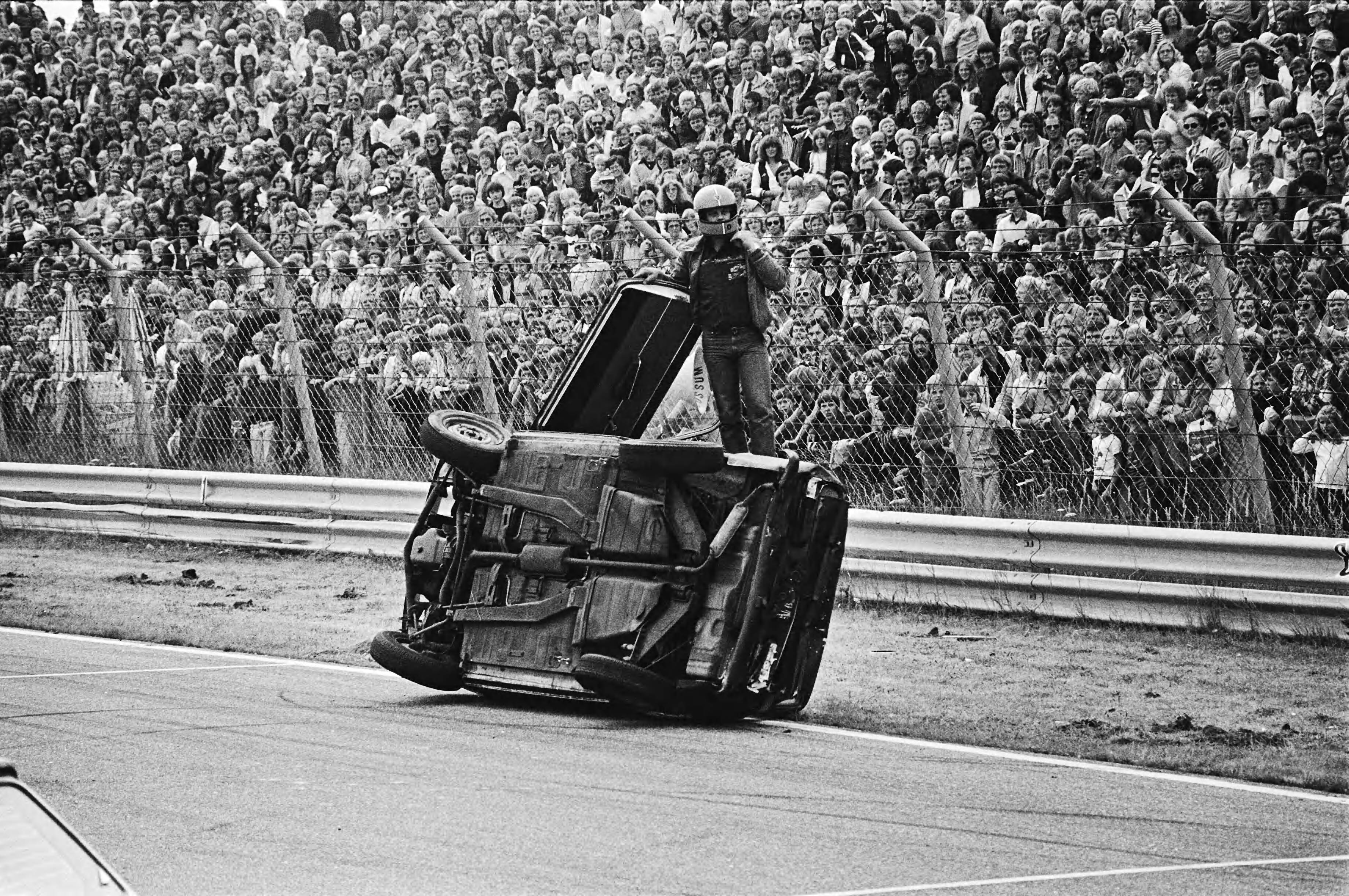 "Ter land, ter zee en in de lucht", opnamen voor het TROS TV programma wedstrijd achteruitrijden op het circuit van Zandvoort — Een DAF coureur bij zijn gekantelde auto — Foto: Suyk, Koen / Anefo. Licentie: Set B: Rechtenvrij / Publiek Domein. Bron: Nationaal Archief. http://hdl.handle.net/10648/acce2020-d0b4-102d-bcf8-003048976d84