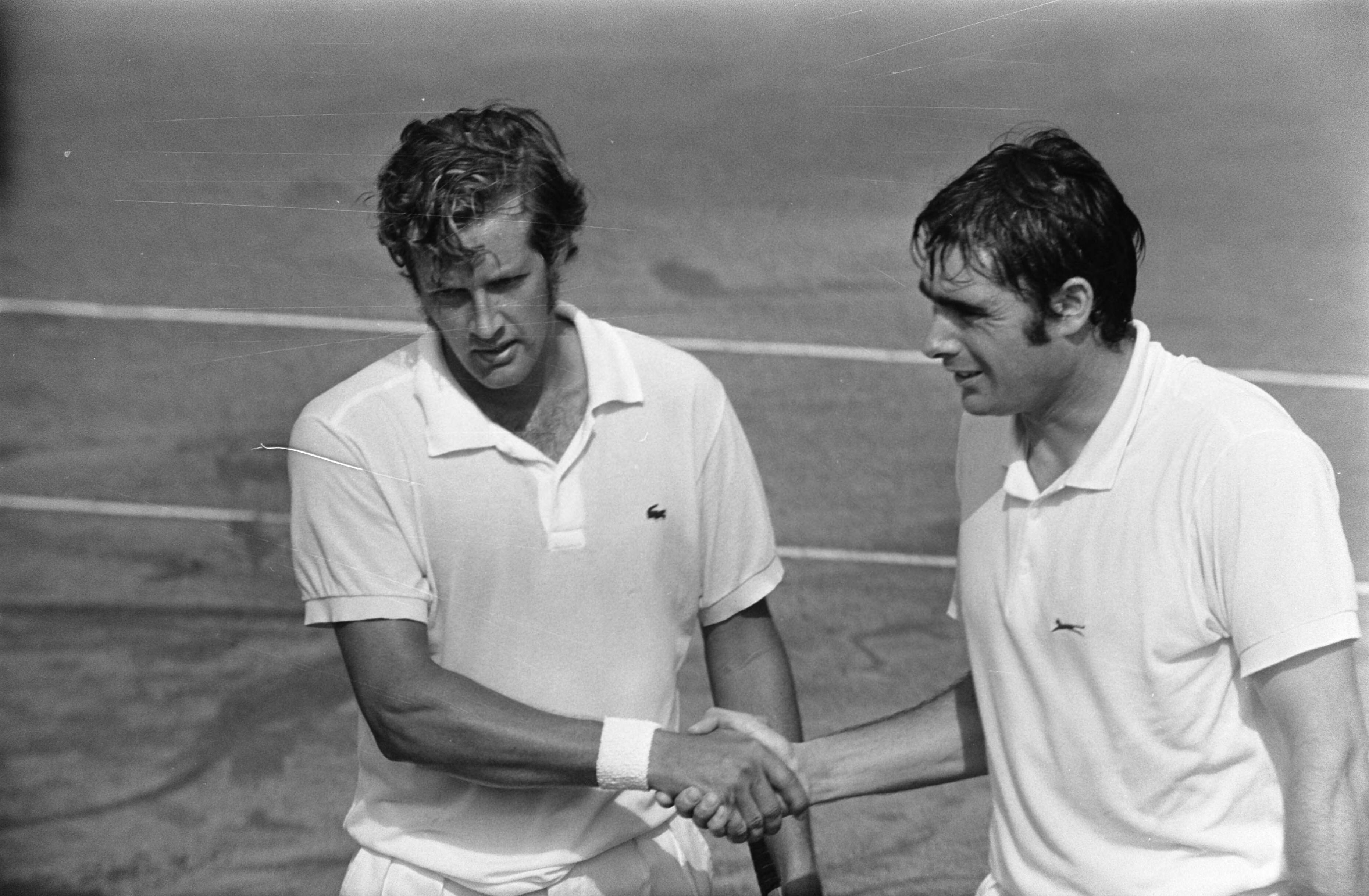 Fotocollectie Anefo — Internationale tenniskampioenschappen in Hilversum ('t Melkhuisje ), Roger Taylor (Engeland) en Nikolas Kalogeropoulos (Griekenland, links) — Foto: Koch, Eric / Anefo. Licentie: Set B: Rechtenvrij / Publiek Domein. Bron: Nationaal Archief. http://hdl.handle.net/10648/ab9e13a4-d0b4-102d-bcf8-003048976d84