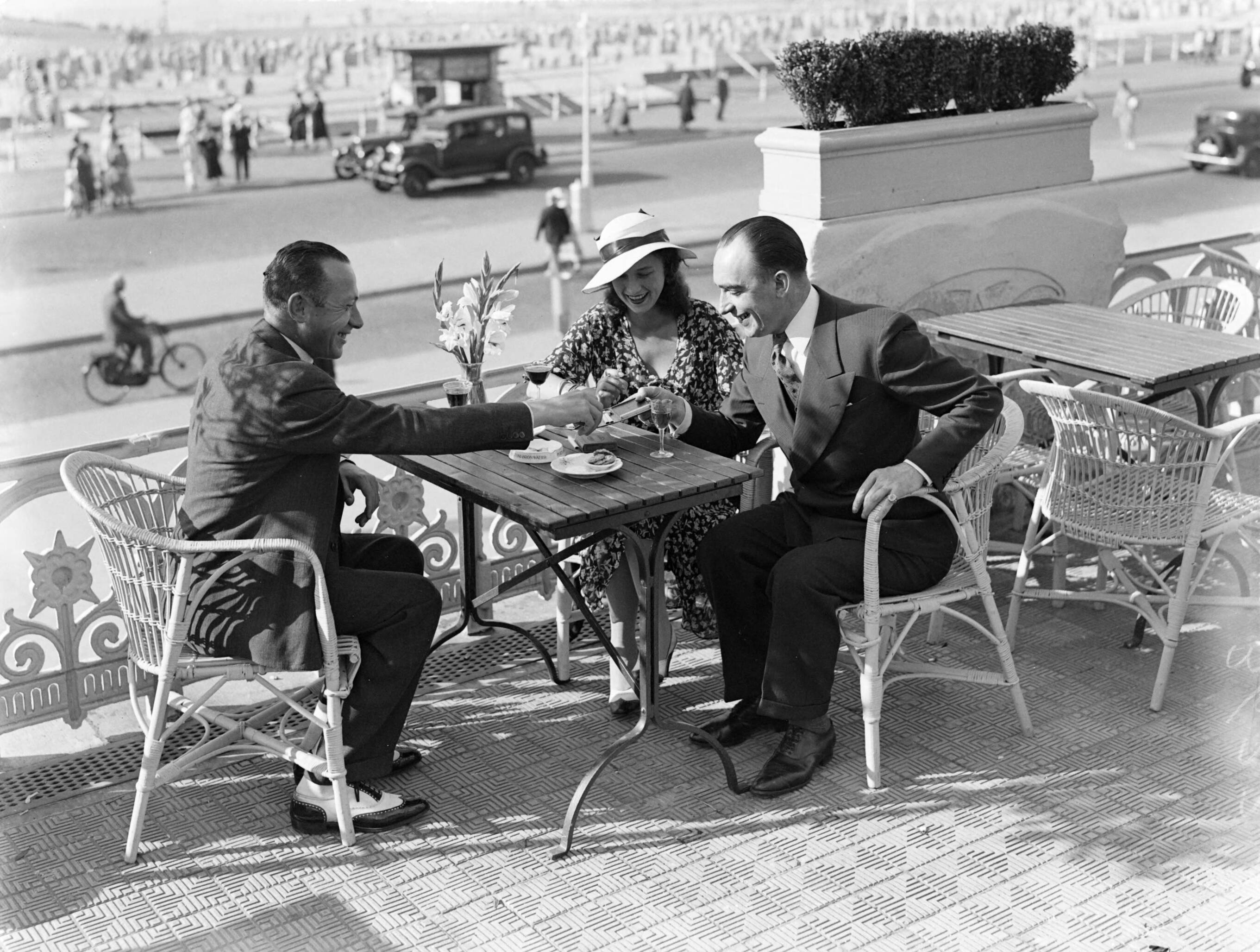 Scheveningen. — Een vrouw (mevrouw Ott?) en twee mannen op een terras aan de boulevard in Scheveningen — Foto: Poll, Willem van de. Licentie: Set B: Rechtenvrij / Publiek Domein. Bron: Nationaal Archief. http://hdl.handle.net/10648/ae9ab486-d0b4-102d-bcf8-003048976d84