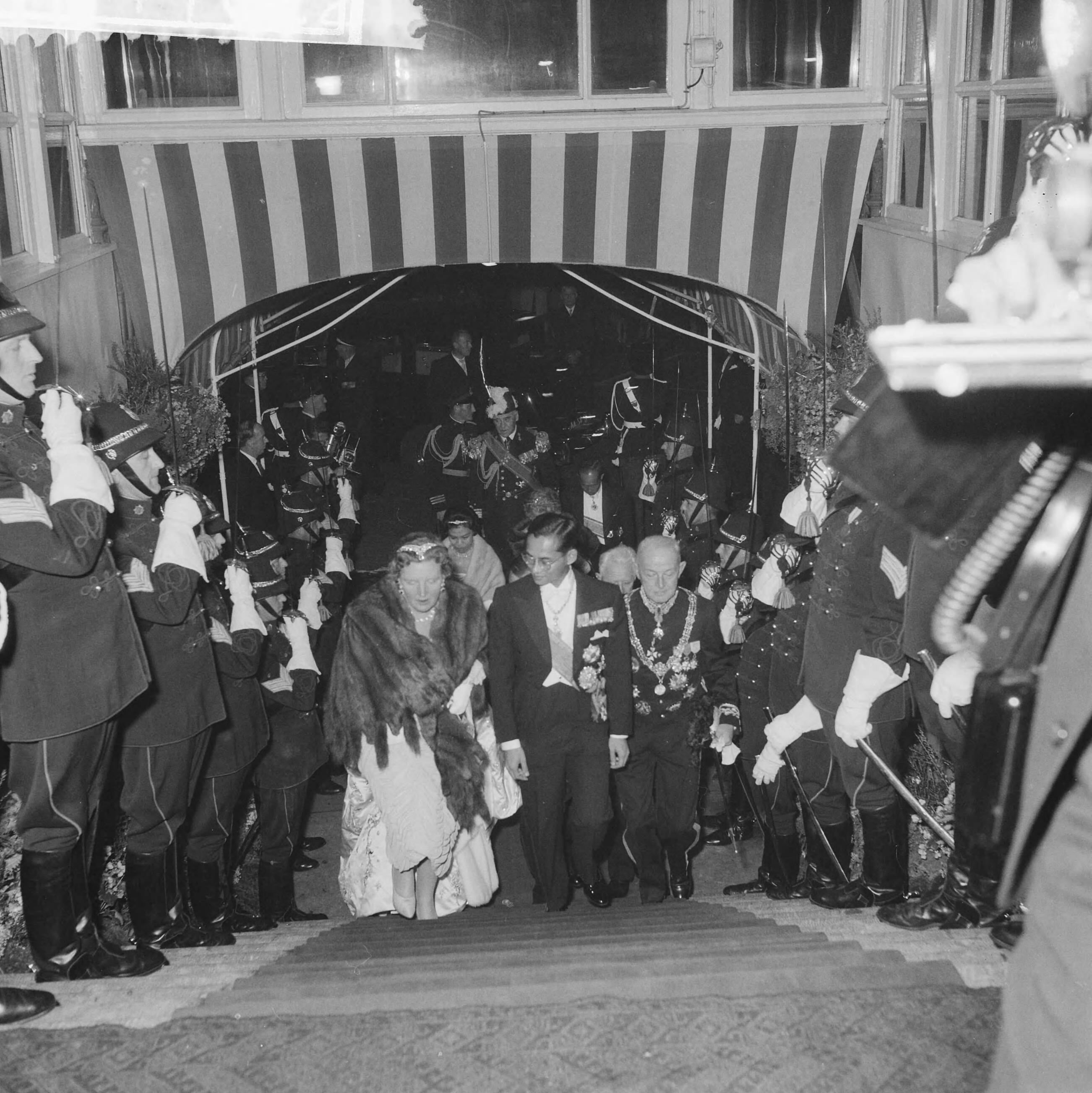 Galaconcert door Koninklijke Militaire Kapel in de Kurzaal te Den Haag — Staatsbezoek koning en koningin van Thailand. Galaconcert door Koninklijke Militaire Kapel in de Kurzaal te Den Haag, het koninklijk gezelschap betreedt het Kurhaus — Foto: Pot, Harry / Anefo. Licentie: Set B: Rechtenvrij / Publiek Domein. Bron: Nationaal Archief. http://hdl.handle.net/10648/a9bc9ab0-d0b4-102d-bcf8-003048976d84