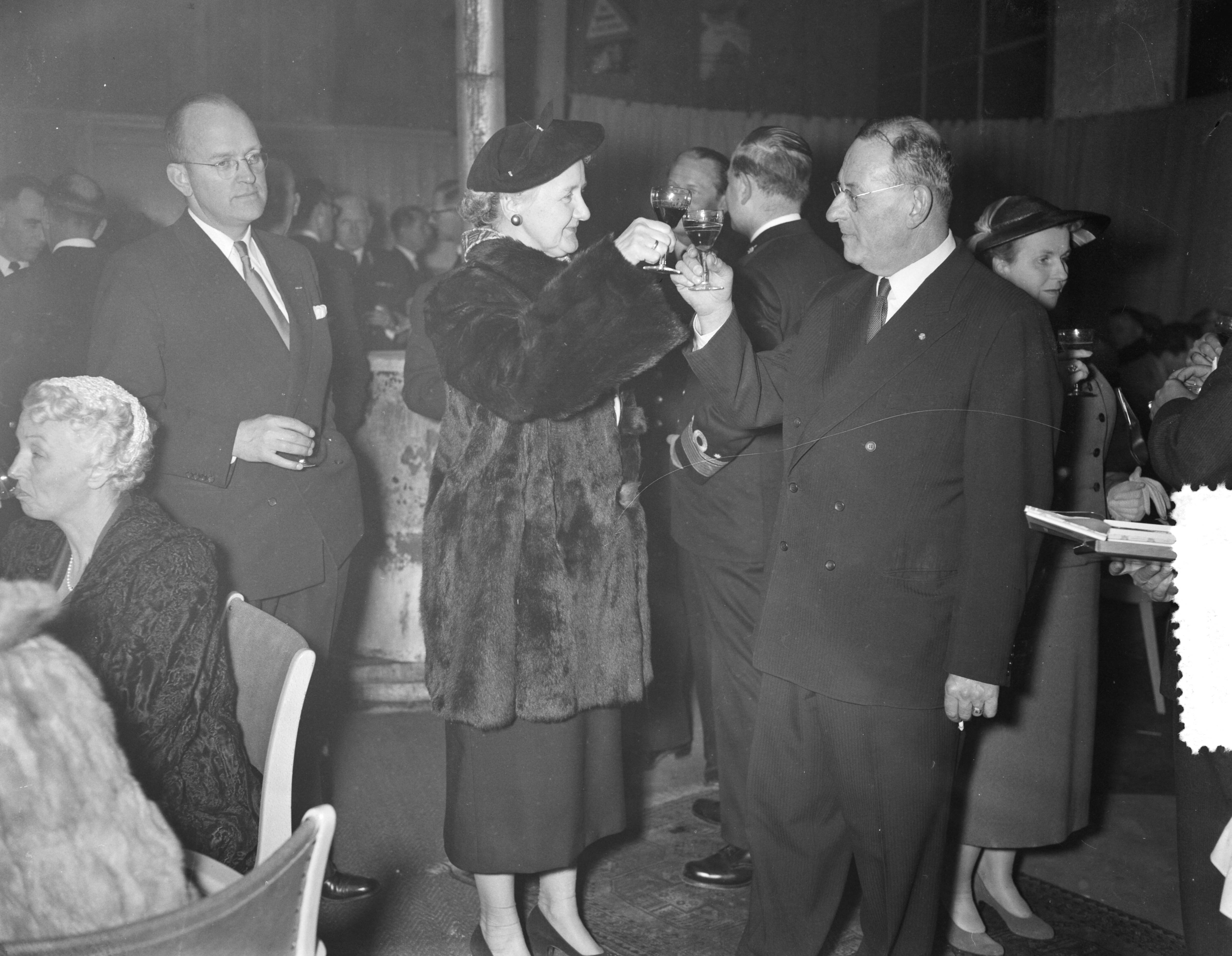 Fotocollectie Anefo — Poging tot tewaterlating van de kustmijnenveger Hr. Ms. "Steenwijk" bij de N.V. Haarlemse Scheepsbouw Maatschappij te Haarlem. De doopplechtigheid werd verricht door mevr. Voetelink-Riemersma, echtgenote van de burgemeester van Steenwijk. Mevrouw Voetelink toost met de directeur van de werf — Foto: Rossem, Wim van / Anefo. Licentie: Set B: Rechtenvrij / Publiek Domein. Bron: Nationaal Archief. http://hdl.handle.net/10648/a9466cfa-d0b4-102d-bcf8-003048976d84