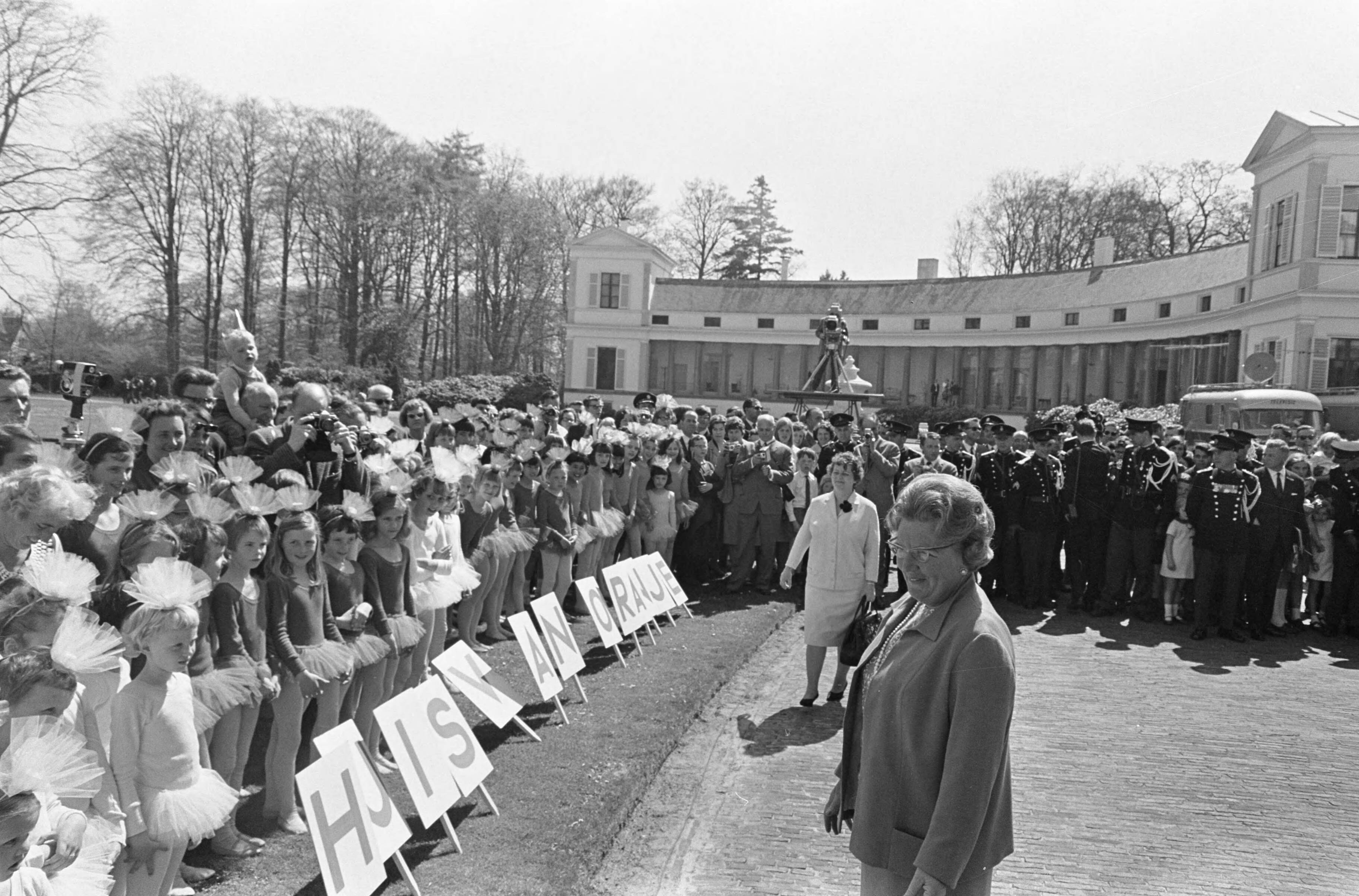 Koninginnedag 1966 — Koningin Juliana bij balletdanseresjes in de voortuin van het paleis — Foto: Fotograaf Onbekend / Anefo. Licentie: Set B: Rechtenvrij / Publiek Domein. Bron: Nationaal Archief. http://hdl.handle.net/10648/aae8118a-d0b4-102d-bcf8-003048976d84