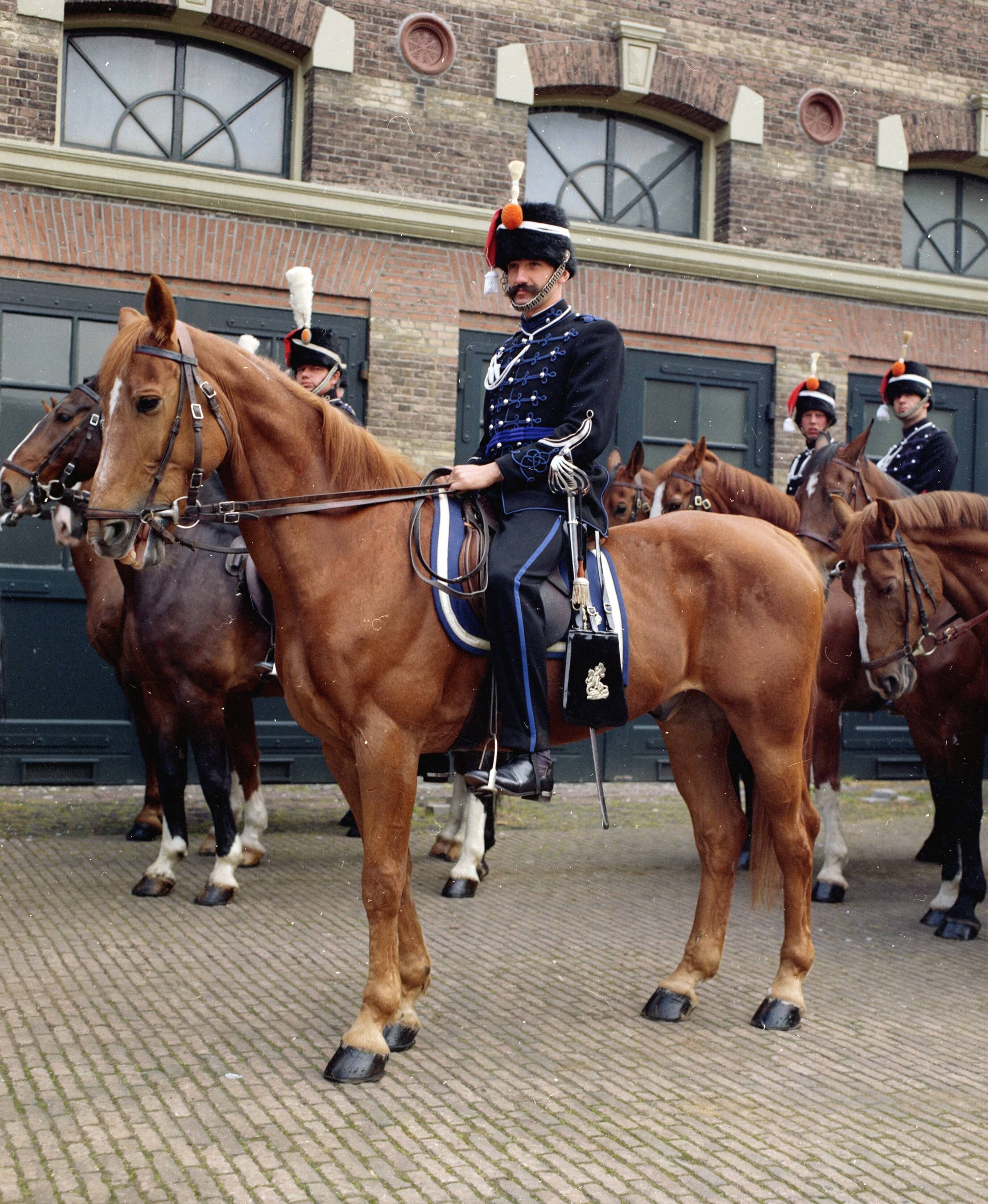 Fotocollectie RVD / Koninklijk Huis — Erewacht in uniform te paard op de binnenplaats van de koninklijke stallen in Den Haag — Foto: Mastenbroek, Cees / RVD. Licentie: Set B: Rechtenvrij / Publiek Domein. Bron: Nationaal Archief. http://hdl.handle.net/10648/afb27dd6-d0b4-102d-bcf8-003048976d84