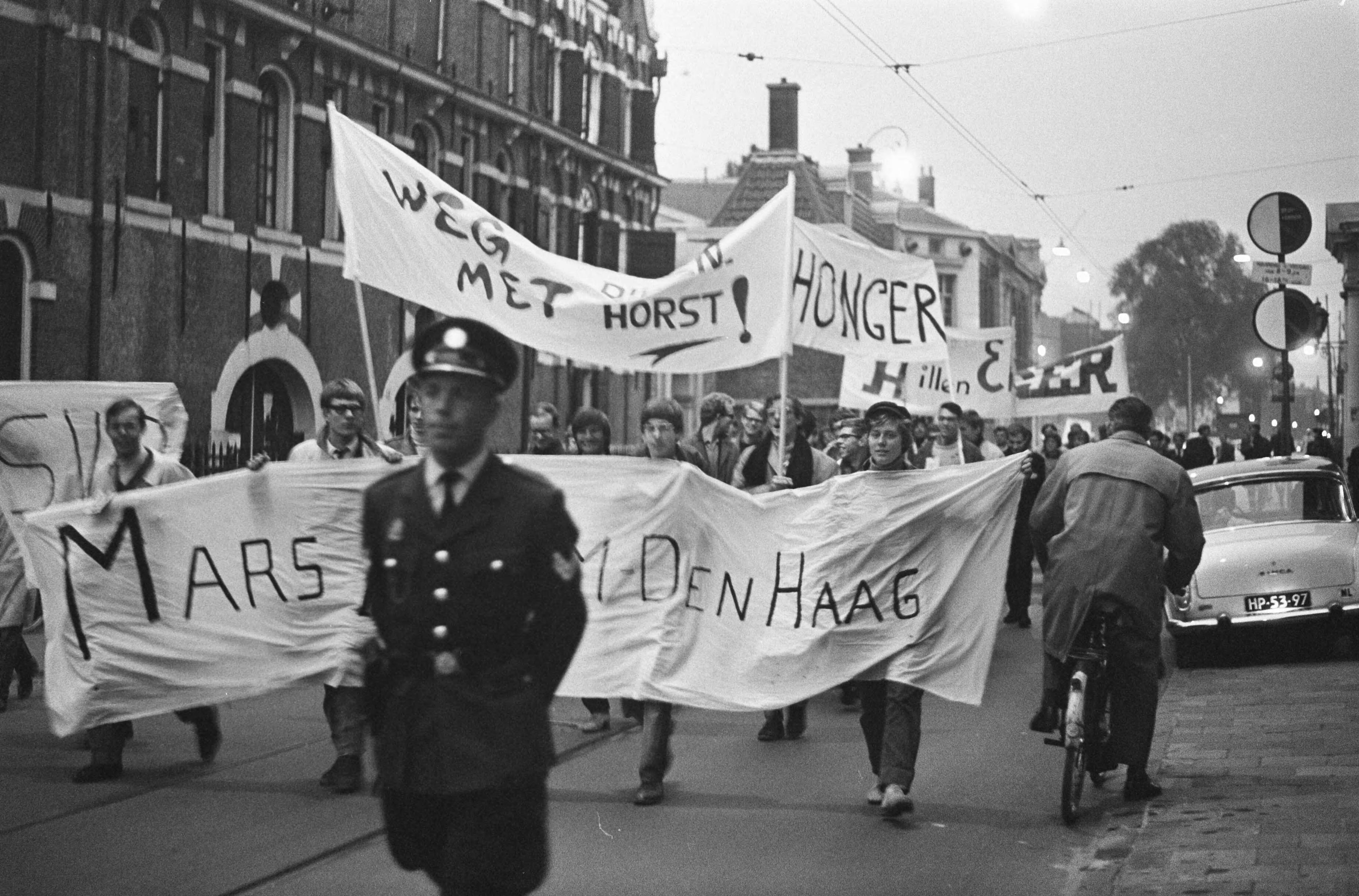 Studentendemonstratie inzake studietoelagen, optocht van Amsterdam naar Den Haag — Betogende studenten lopen met spandoeken met diversen opschriften — Foto: Fotograaf Onbekend / Anefo. Licentie: Set B: Rechtenvrij / Publiek Domein. Bron: Nationaal Archief. http://hdl.handle.net/10648/aafe2b78-d0b4-102d-bcf8-003048976d84