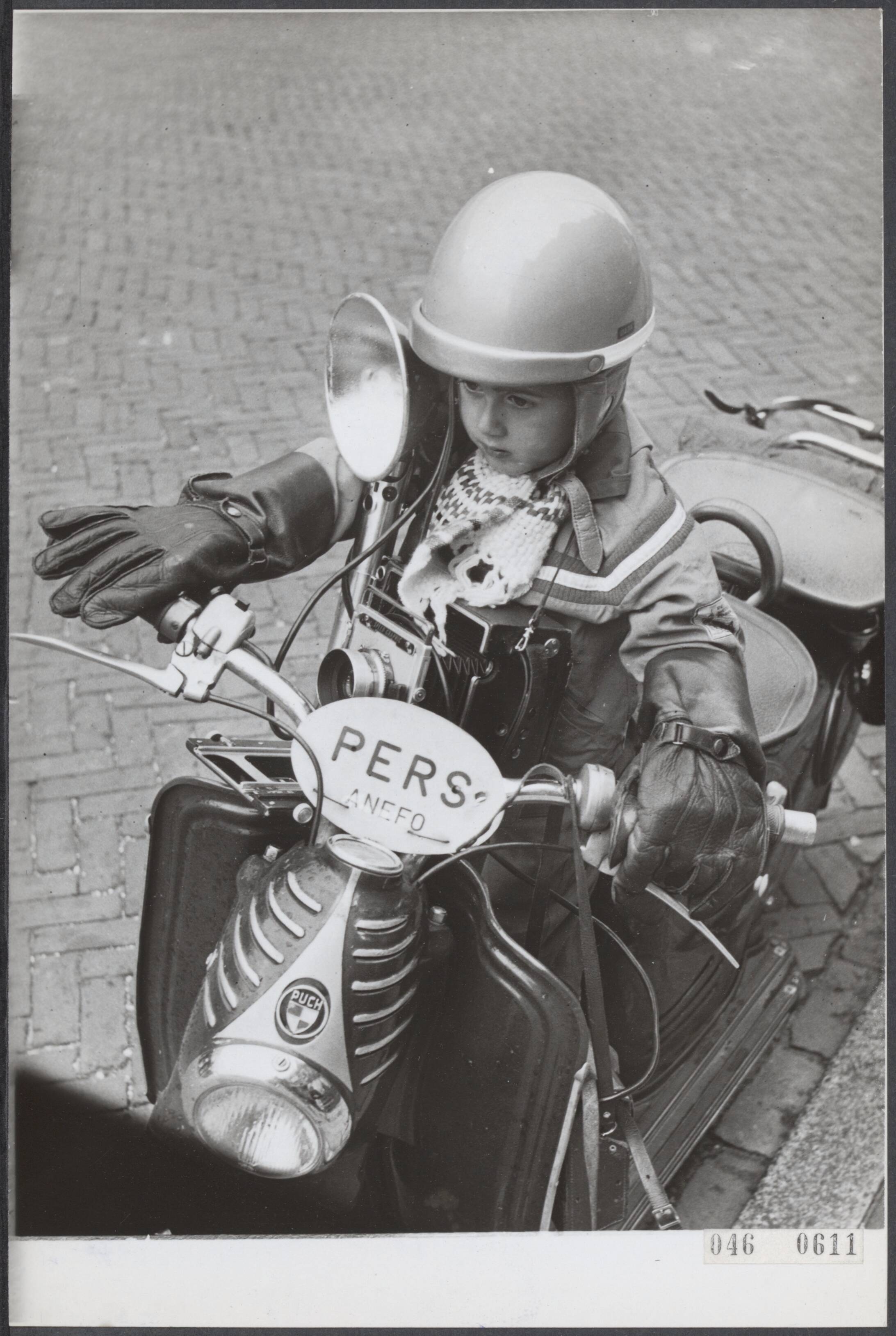 Fotocollectie Elsevier Binnenland — Harry Pot, persfotograaf in Zandvoort heeft een zoon, die kennnelijk dit ambacht ambieert en vooral veel interesse heeft om de telefonische opdrachten aan te nemen en dan met motorhelm en scooter zich naar het "onderwerp" te begeven — Foto: Pot, Harry / Anefo. Licentie: Set B: Rechtenvrij / Publiek Domein. Bron: Nationaal Archief. http://hdl.handle.net/10648/adfe5870-d0b4-102d-bcf8-003048976d84