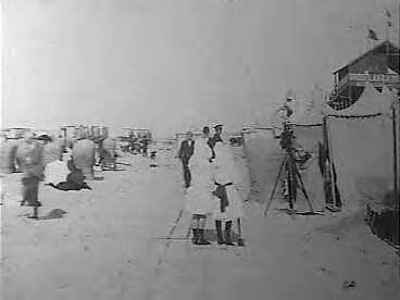 Fotocollectie Elsevier Binnenland — Strand van Scheveningen met badgasten. Een fotografe neemt een foto — Foto: Onbekend / Publiek Domein of Rechtenvrij. Licentie: Set B: Rechtenvrij / Publiek Domein. Bron: Nationaal Archief. http://hdl.handle.net/10648/addf8030-d0b4-102d-bcf8-003048976d84