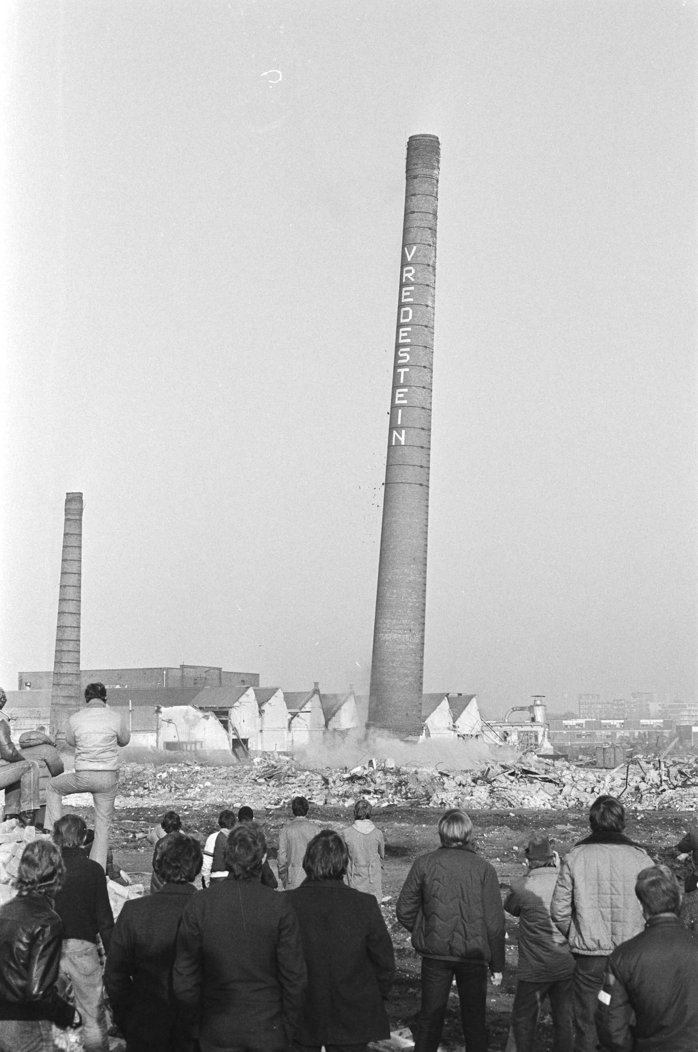 Fotocollectie Anefo — Twee grote schoorstenen van voormalige Vredestein-fabriek in Den Haag opgeblazen — Foto: Dijk, Hans van / Anefo. Licentie: Set B: Rechtenvrij / Publiek Domein. Bron: Nationaal Archief. http://hdl.handle.net/10648/ad0d86d4-d0b4-102d-bcf8-003048976d84