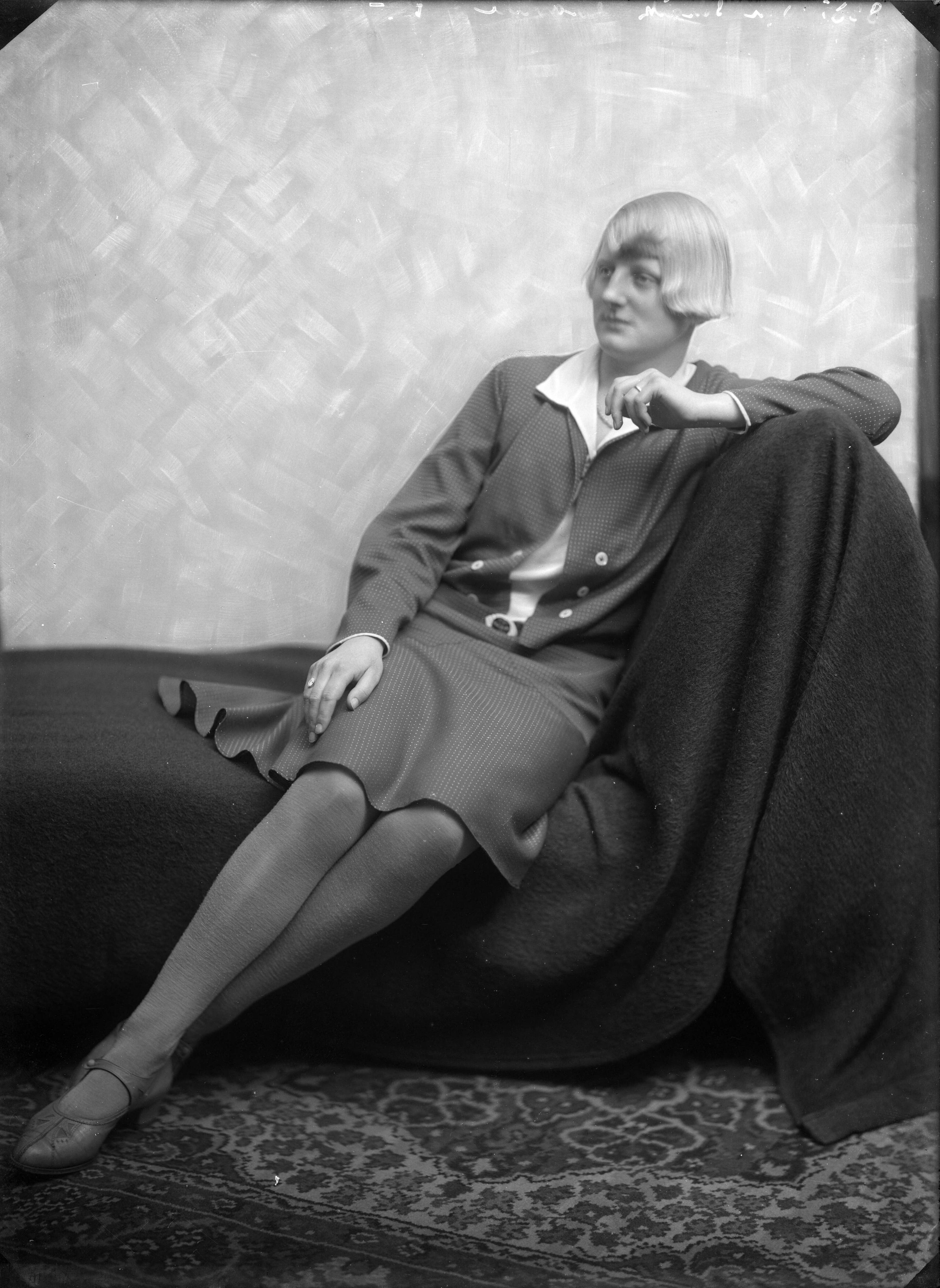 Portretten — Studio-opnames. Een zittende vrouw met blond bob-kapsel in een jurk met klokrok en lange mouwen. Haarlem, Nederland 1918-1930. 8385 Van Schaik gravure — Foto: Berg, Th.C.J. van den / Spaarnestad Photo (05887). Licentie: Set B: Rechtenvrij / Publiek Domein. Bron: Nationaal Archief. http://hdl.handle.net/10648/35429da7-c5bc-a382-e063-6df0900a6686