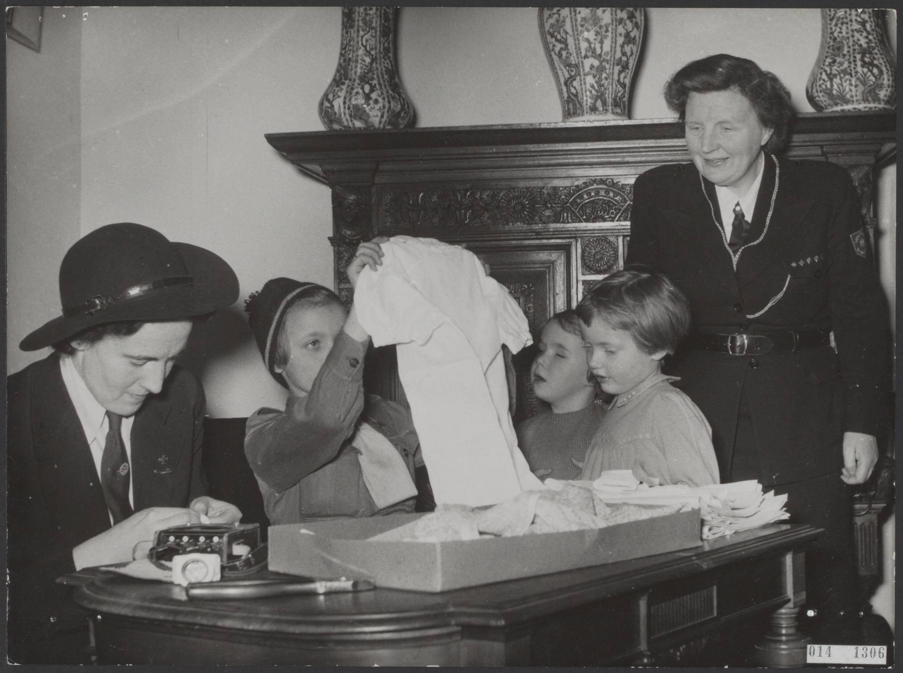 Fotocollectie Elsevier Binnenland — Actie "Heitje voor een karweitje" op het paleis Soestdijk. Kleren werden gesorteerd en uitgeklopt en maiskolven werden geplukt. De koningin in padvindersuniform, derde van rechts prinses Marijke/Christina — Foto: Fotograaf Onbekend / Anefo. Licentie: Set B: Rechtenvrij / Publiek Domein. Bron: Nationaal Archief. http://hdl.handle.net/10648/adb35f14-d0b4-102d-bcf8-003048976d84