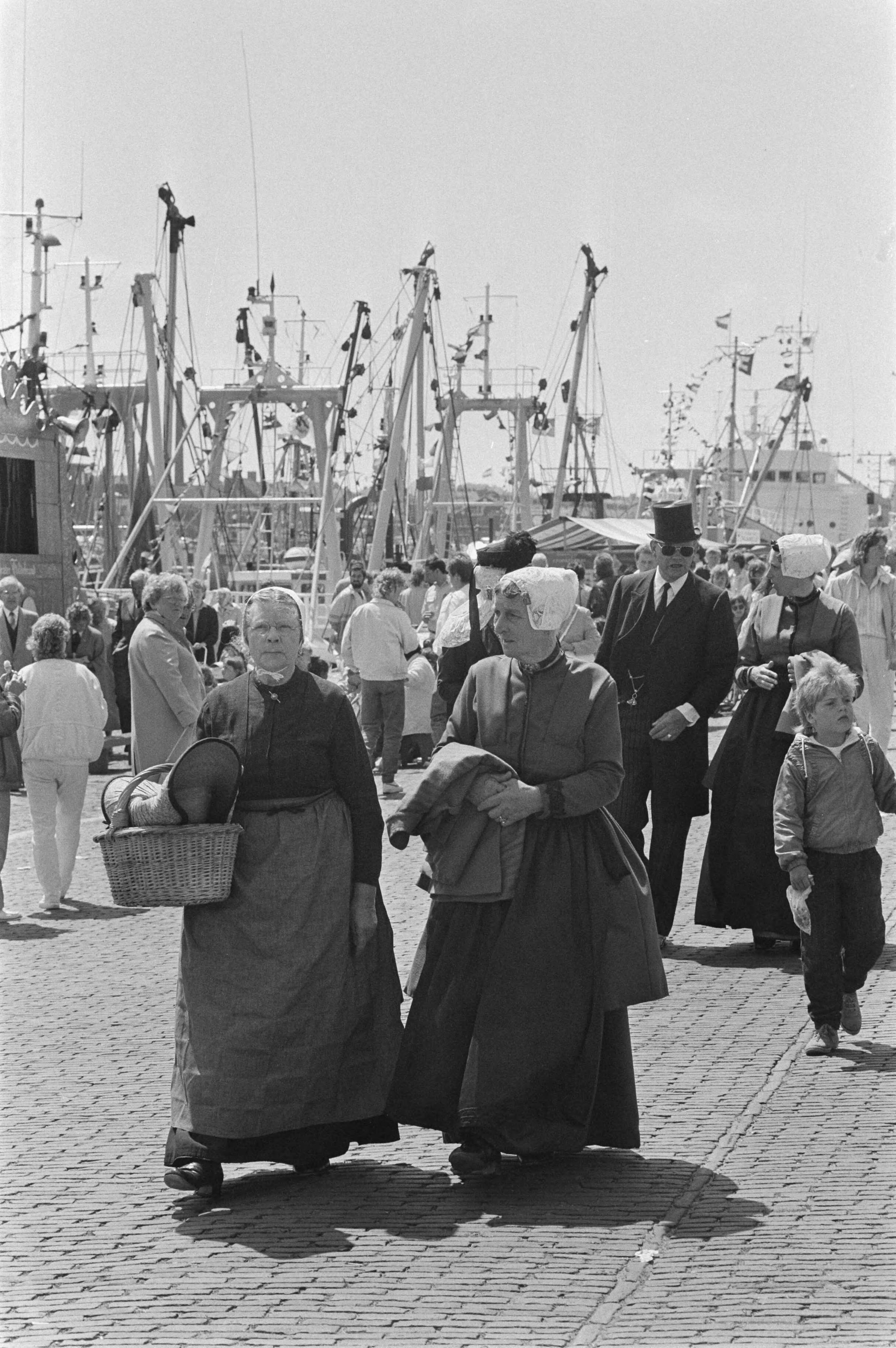Fotocollectie Anefo — Traditionele Vlaggetjesdag in Scheveningen aan begin haringvangst; bezoekers lopen langs gepavoiseerde schepen in Scheveningse haven — Foto: Croes, Rob C. / Anefo. Licentie: Set B: Rechtenvrij / Publiek Domein. Bron: Nationaal Archief. http://hdl.handle.net/10648/ad5399a8-d0b4-102d-bcf8-003048976d84
