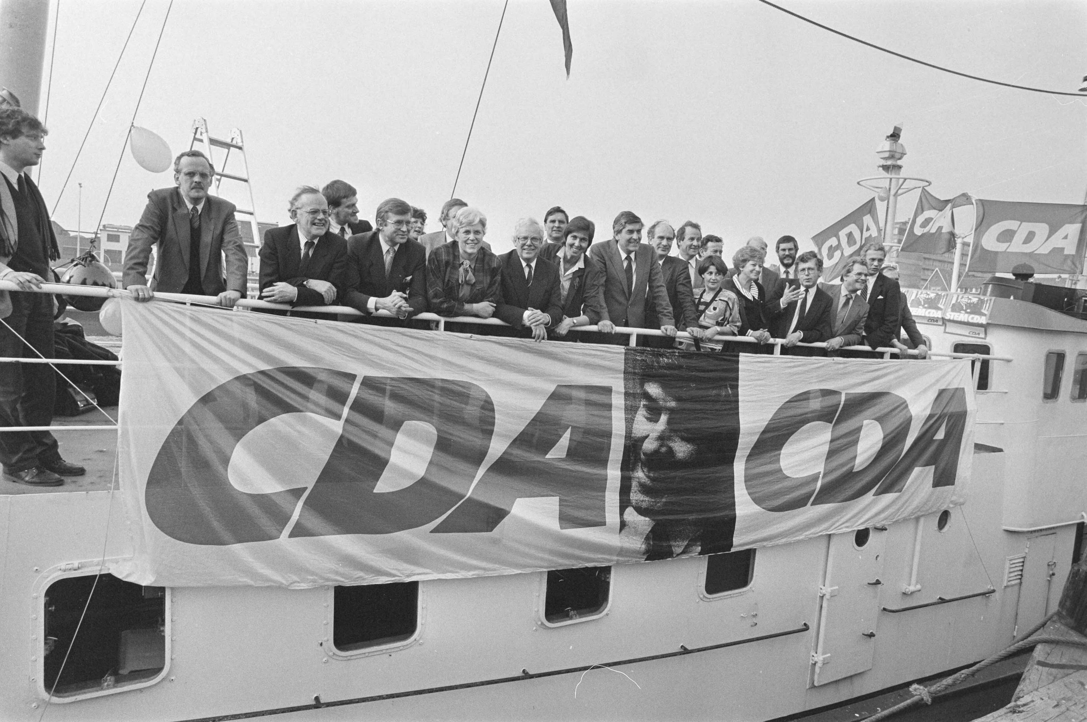 Groepsfoto CDA te Scheveningen — Zuid-Holland|Scheveningen|spandoeken |politieke partijen |portretten|CDA — Foto: Bogaerts, Rob / Anefo. Licentie: Set B: Rechtenvrij / Publiek Domein. Bron: Nationaal Archief. http://hdl.handle.net/10648/ad5120ba-d0b4-102d-bcf8-003048976d84