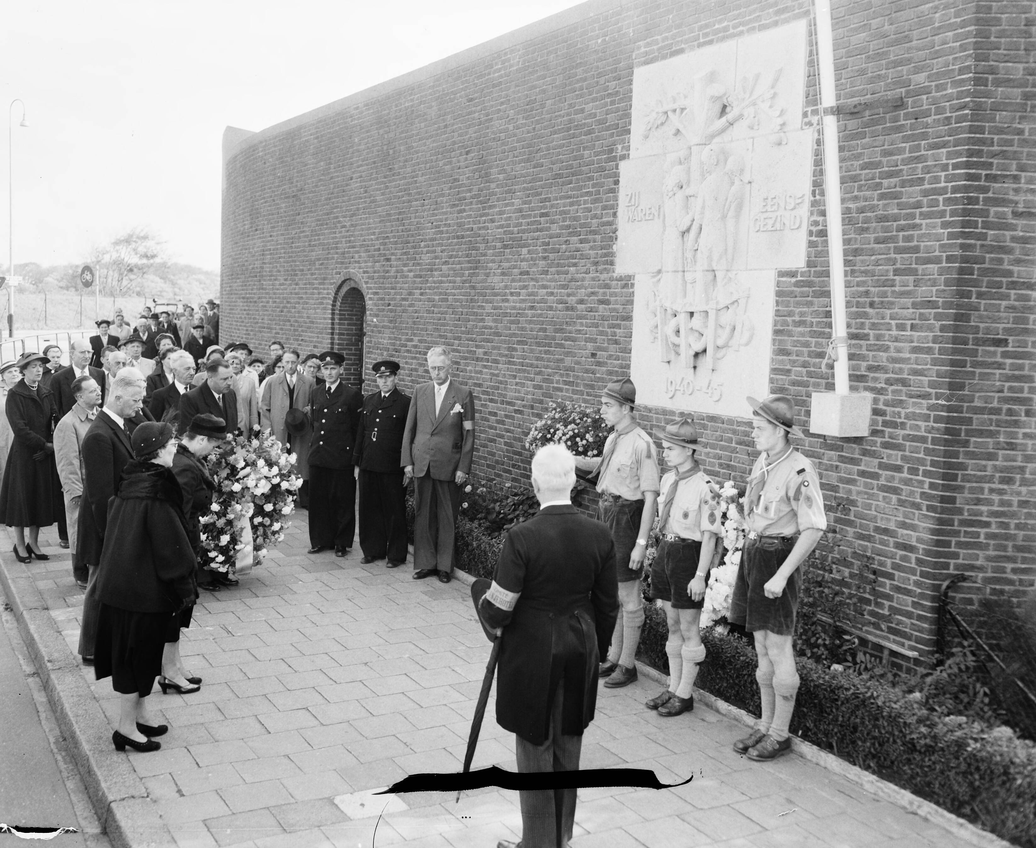 Fotocollectie Anefo — Herdenking dodencel 601 "Oranjehotel" te Scheveningen. Mej. mr. M. Geldens legde een krans namens prinses Wilhelmina — Foto: Pot, Harry / Anefo. Licentie: Set B: Rechtenvrij / Publiek Domein. Bron: Nationaal Archief. http://hdl.handle.net/10648/a94fded4-d0b4-102d-bcf8-003048976d84