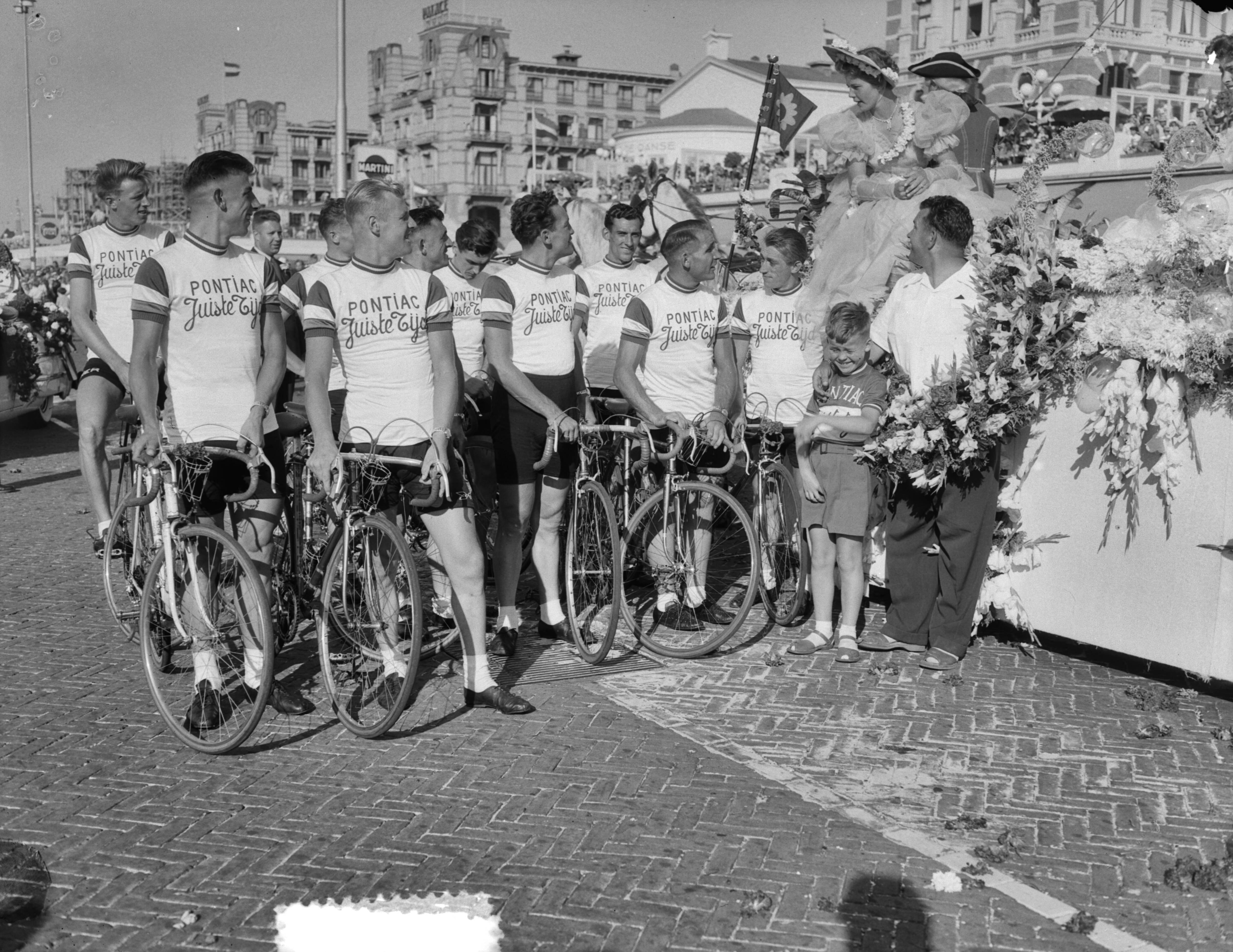 Bloemencorso in Den Haag 1953 — Bloemencorso in Den Haag. Tour de France ploeg op de fiets — Foto: Duinen, G.W. van / Anefo. Licentie: Set B: Rechtenvrij / Publiek Domein. Bron: Nationaal Archief. http://hdl.handle.net/10648/a910bf7e-d0b4-102d-bcf8-003048976d84