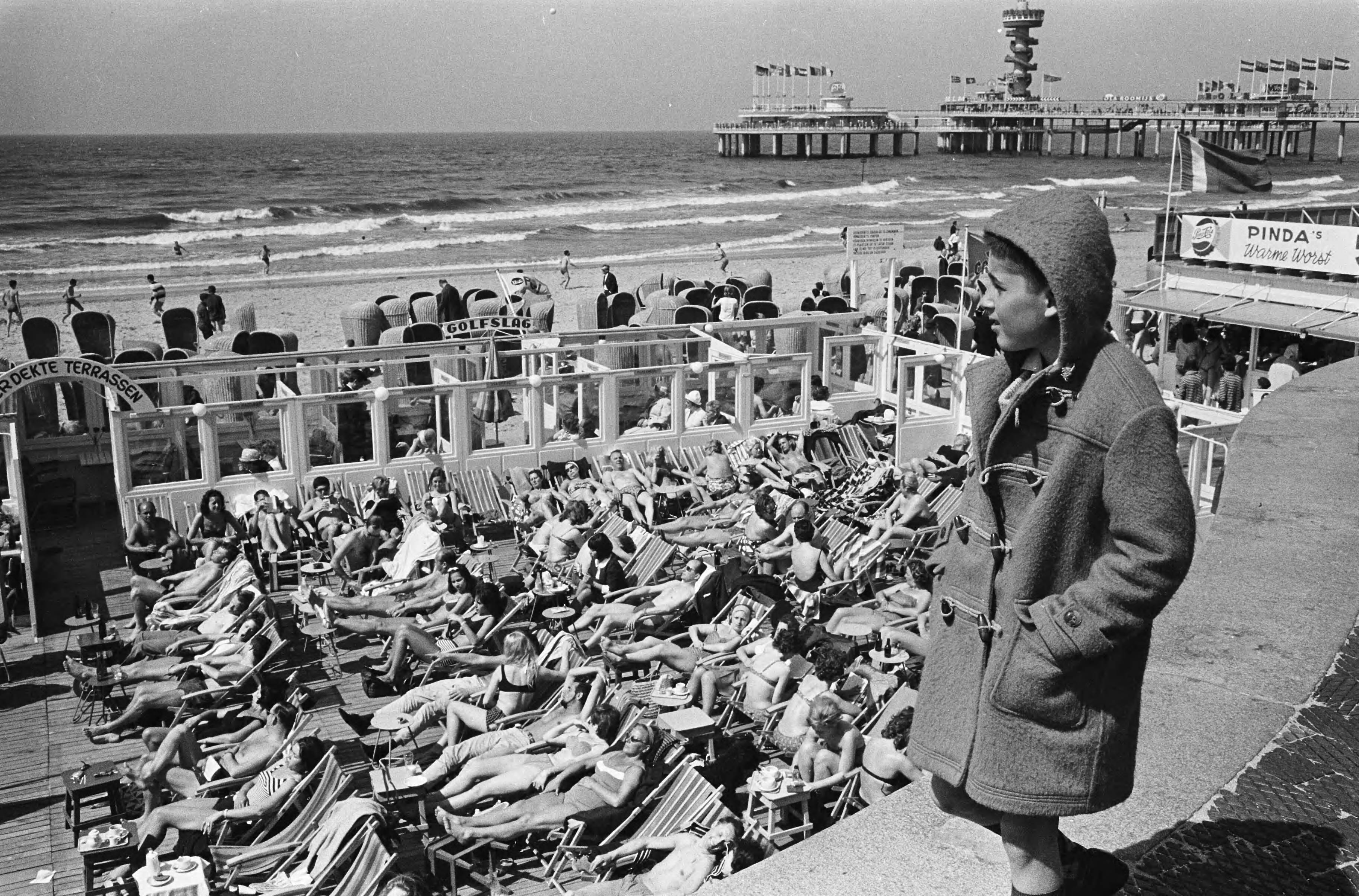 Fotocollectie Anefo — Drukte op Scheveningse strandterrasjes — Foto: Pot, Harry / Anefo. Licentie: Set B: Rechtenvrij / Publiek Domein. Bron: Nationaal Archief. http://hdl.handle.net/10648/aa689a18-d0b4-102d-bcf8-003048976d84