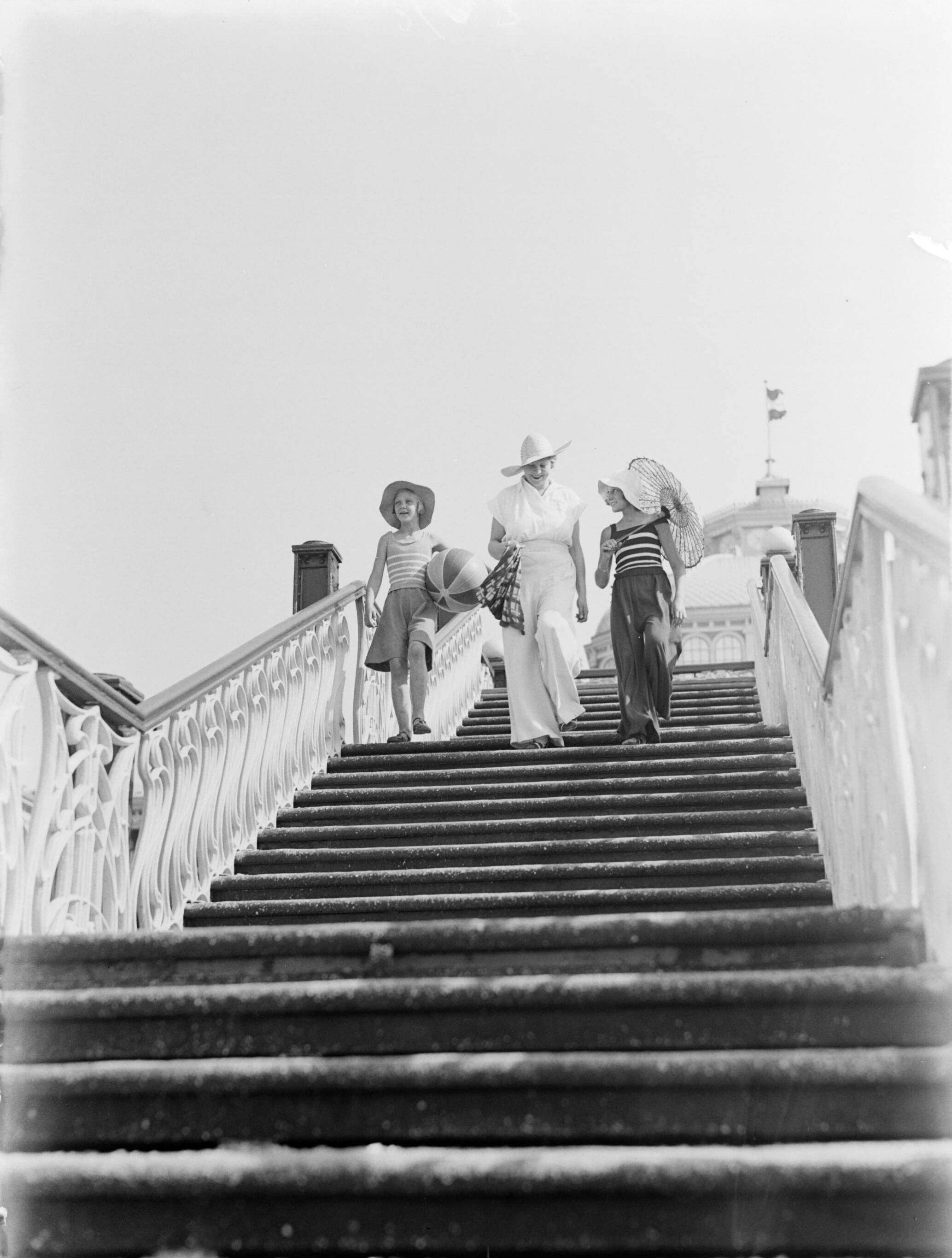 Scheveningen. — Van de Polls vrouw Nell Langlais en zijn stiefdochters Renée en Hans op een trap aan de boulevard van Scheveningen — Foto: Poll, Willem van de. Licentie: Set B: Rechtenvrij / Publiek Domein. Bron: Nationaal Archief. http://hdl.handle.net/10648/ae9b1f84-d0b4-102d-bcf8-003048976d84
