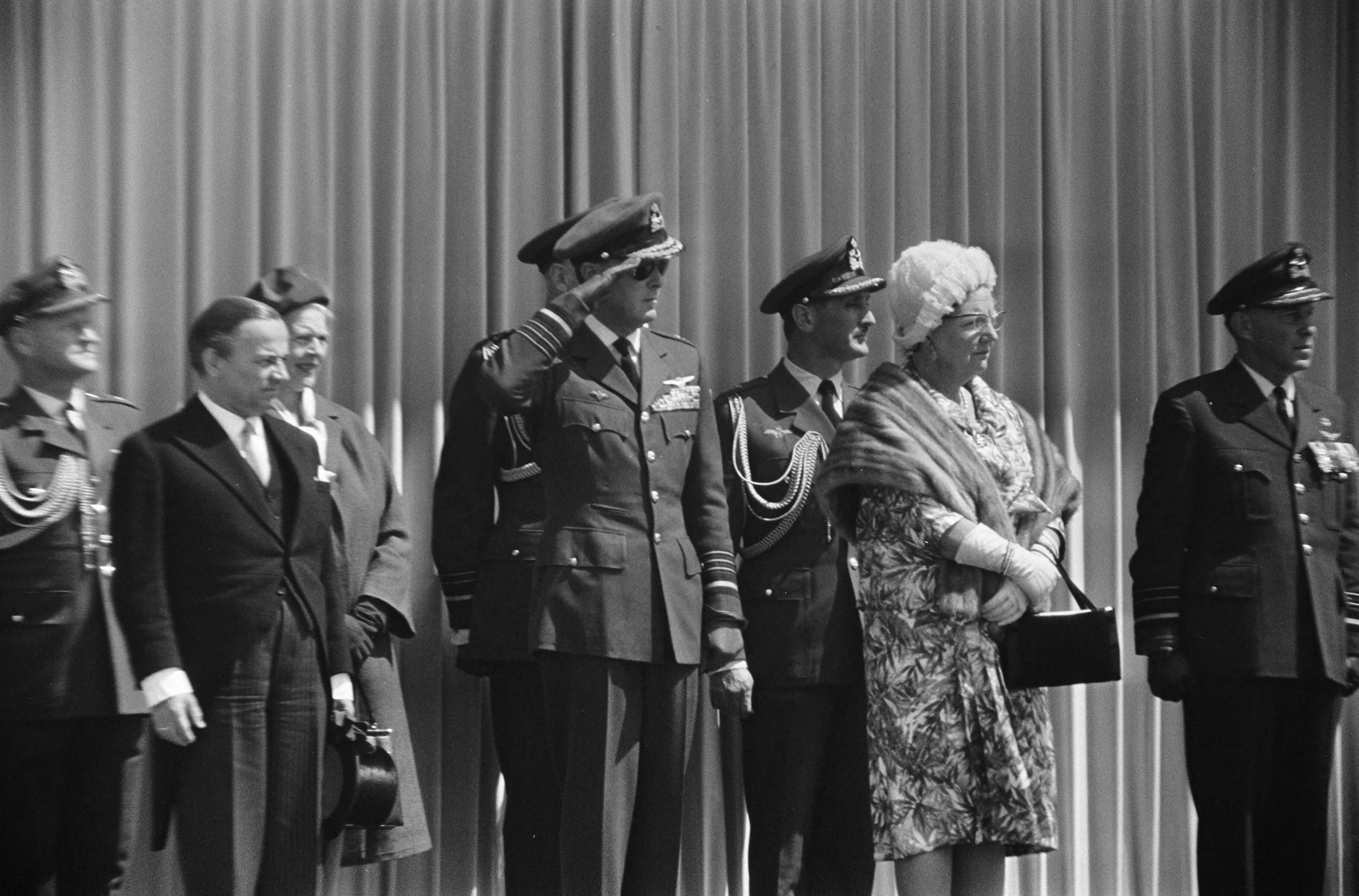 Fotocollectie Anefo — Koningin Juliana geeft vaandel aan de Koninklijke Luchtmacht, tijdens het defilé, vlnr. minister De Jong, prins Bernhard en koningin Juliana — Foto: Koch, Eric / Anefo. Licentie: Set B: Rechtenvrij / Publiek Domein. Bron: Nationaal Archief. http://hdl.handle.net/10648/aaa95648-d0b4-102d-bcf8-003048976d84