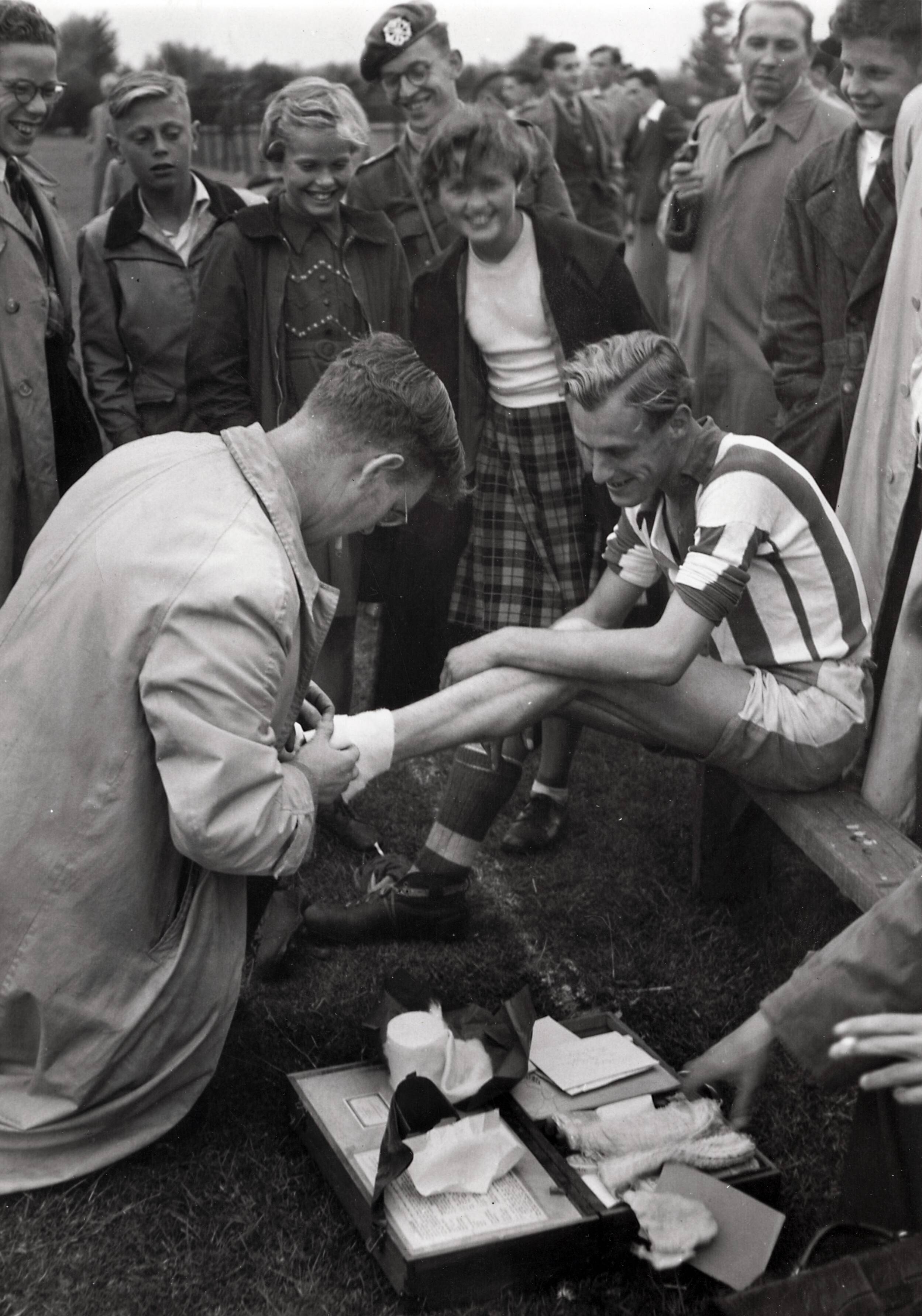 Sportactiviteiten personeel Drukkerij N.V. De Spaarnestad / Voetbal, o.a. F.C. Panorama — [Serie bedrijfsvoetbal Spaarnestad, diverse jaren] Spaarnestad - De Tijd. Verbandmeester Smit in volle actie — Foto: Fotograaf Onbekend / Spaarnestad / Spaarnestad Photo (05887). Licentie: Set B: Rechtenvrij / Publiek Domein. Bron: Nationaal Archief. http://hdl.handle.net/10648/35429da6-3f0a-a382-e063-6df0900a6686