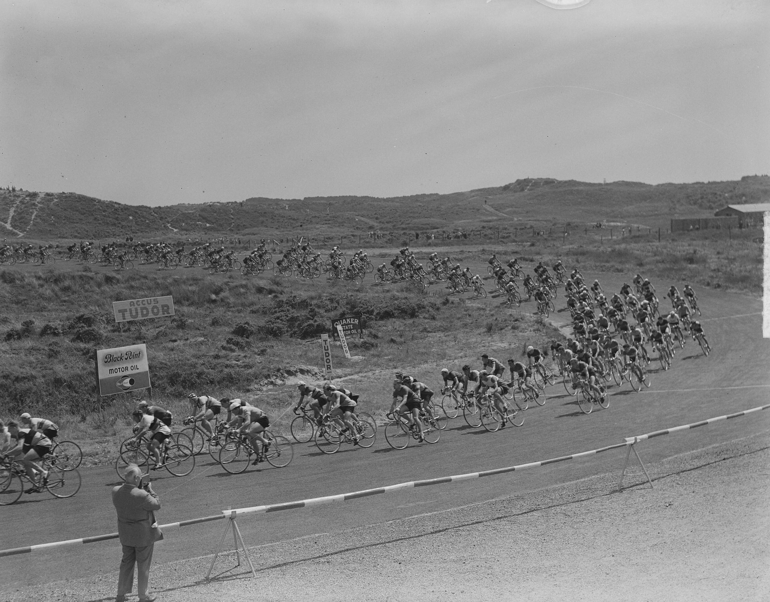 Nederlands kampioenschap wielrennen voor amateurs 1951 — Nederlands kampioenschap wielrennen voor amateurs op het circuit van Zandvoort. Het peloton in de Tarzanbocht — Foto: Noske, J.D. / Anefo. Licentie: Set B: Rechtenvrij / Publiek Domein. Bron: Nationaal Archief. http://hdl.handle.net/10648/a8ecc89e-d0b4-102d-bcf8-003048976d84