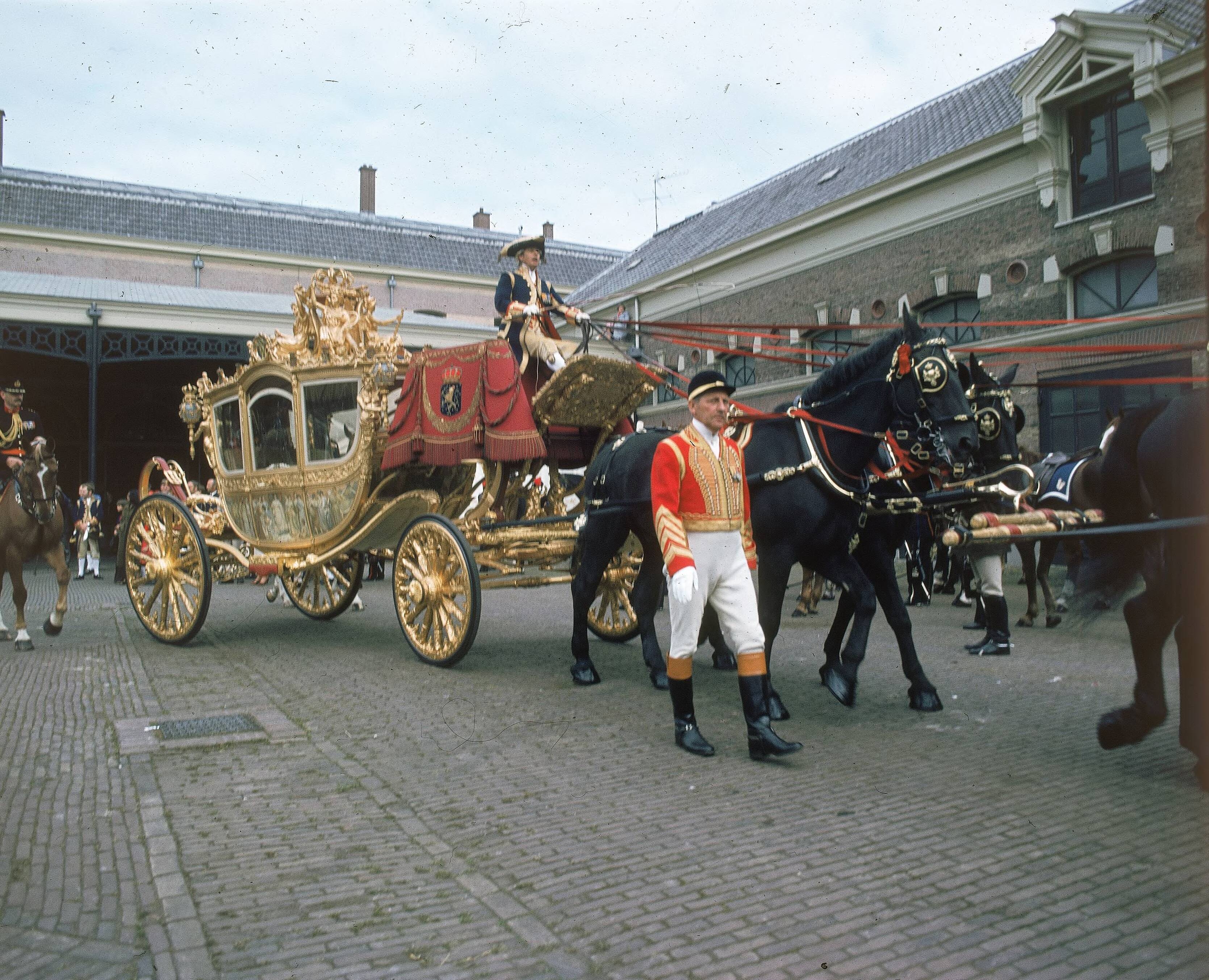 Fotocollectie RVD / Koninklijk Huis — Prinsjesdag - Gouden koets, met koetsier, stalpersoneel en paarden op de binnenplaats van de koninklijke stallen aan de Noordwal te Den Haag — Foto: Mastenbroek, Cees / RVD. Licentie: Set B: Rechtenvrij / Publiek Domein. Bron: Nationaal Archief. http://hdl.handle.net/10648/afb2758e-d0b4-102d-bcf8-003048976d84