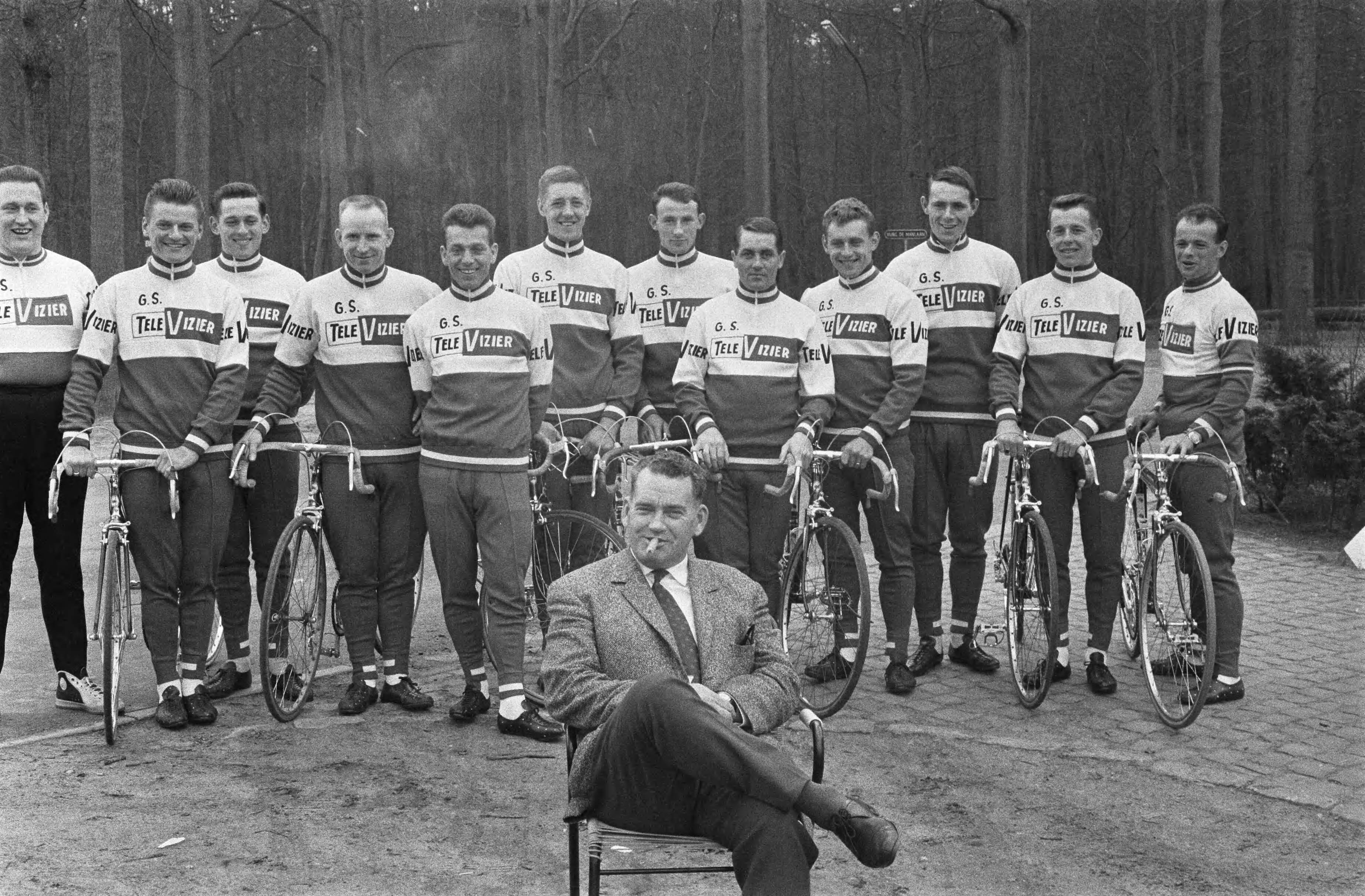 Fotocollectie Anefo — Nederlandse wielerploeg voor Tour de France 1964 gepresenteerd, hele ploeg met in de voorgrond een zittende ploegleider Kees Pellenaars — Foto: Pot, Harry / Anefo. Licentie: Set B: Rechtenvrij / Publiek Domein. Bron: Nationaal Archief. http://hdl.handle.net/10648/aa60e174-d0b4-102d-bcf8-003048976d84
