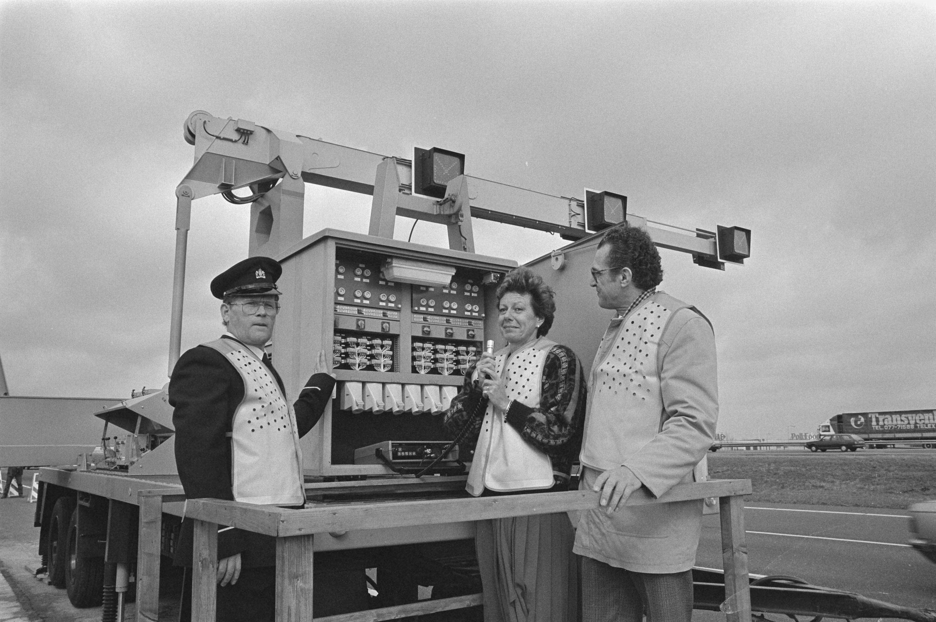 Minister Kroes van Verkeer en Waterstaat stelt langs de A12 de nieuwste mobiele rijstrook signalering in werking — Kroes, Neelie|Reeuwijk|Zuid-Holland|snelwegen |straatmeubilair |wegwerkzaamheden |ministers |verkeer — Foto: Croes, Rob C. / Anefo. Licentie: Set B: Rechtenvrij / Publiek Domein. Bron: Nationaal Archief. http://hdl.handle.net/10648/ad5220c8-d0b4-102d-bcf8-003048976d84