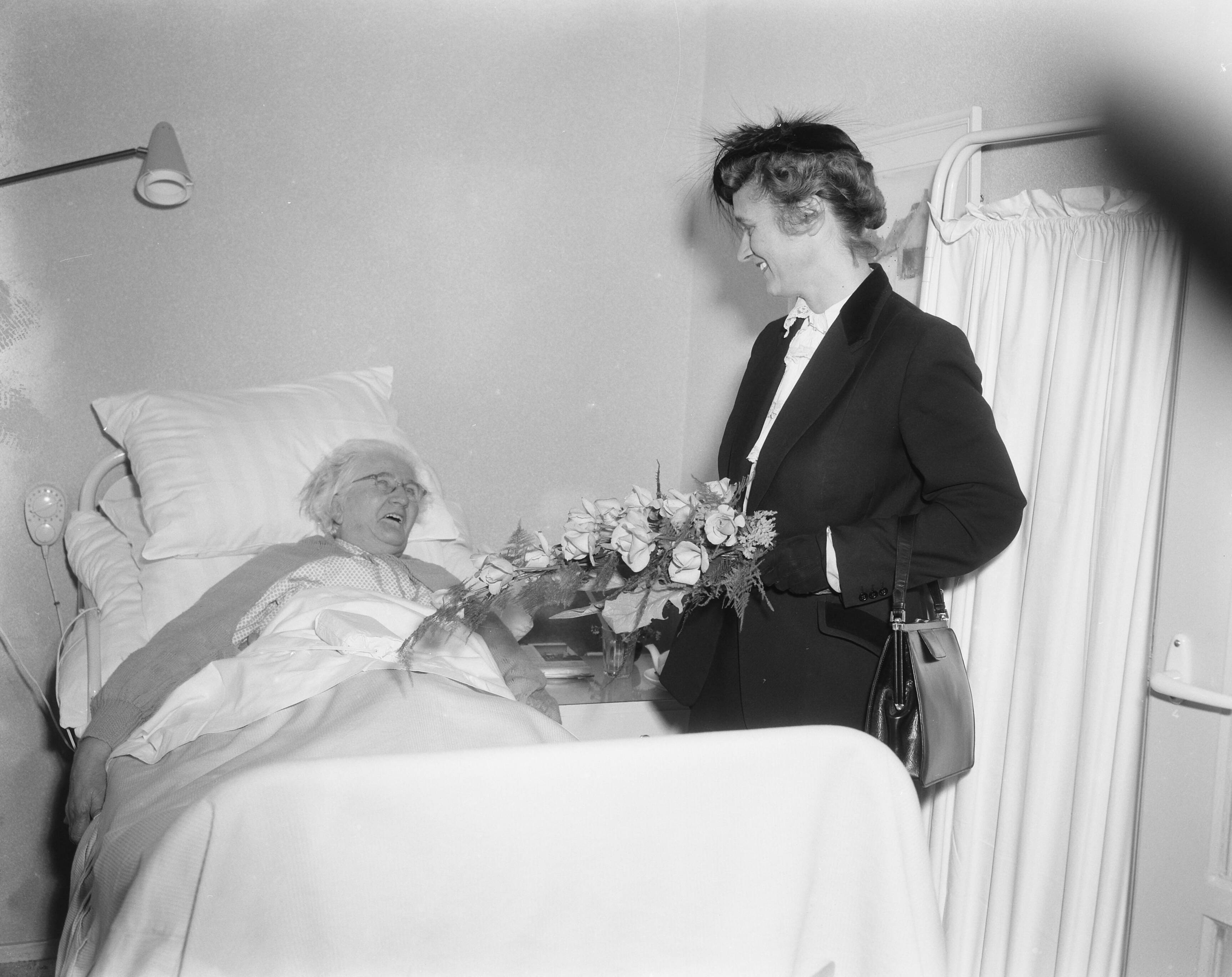 Fotocollectie Anefo — Opening bejaardencentrum Twickelstraat Den Haag. Minister mej. mr. dr. M. Klompé in gesprek met een bejaarde vrouw — Foto: Pot, Harry / Anefo. Licentie: Set B: Rechtenvrij / Publiek Domein. Bron: Nationaal Archief. http://hdl.handle.net/10648/a95cb604-d0b4-102d-bcf8-003048976d84