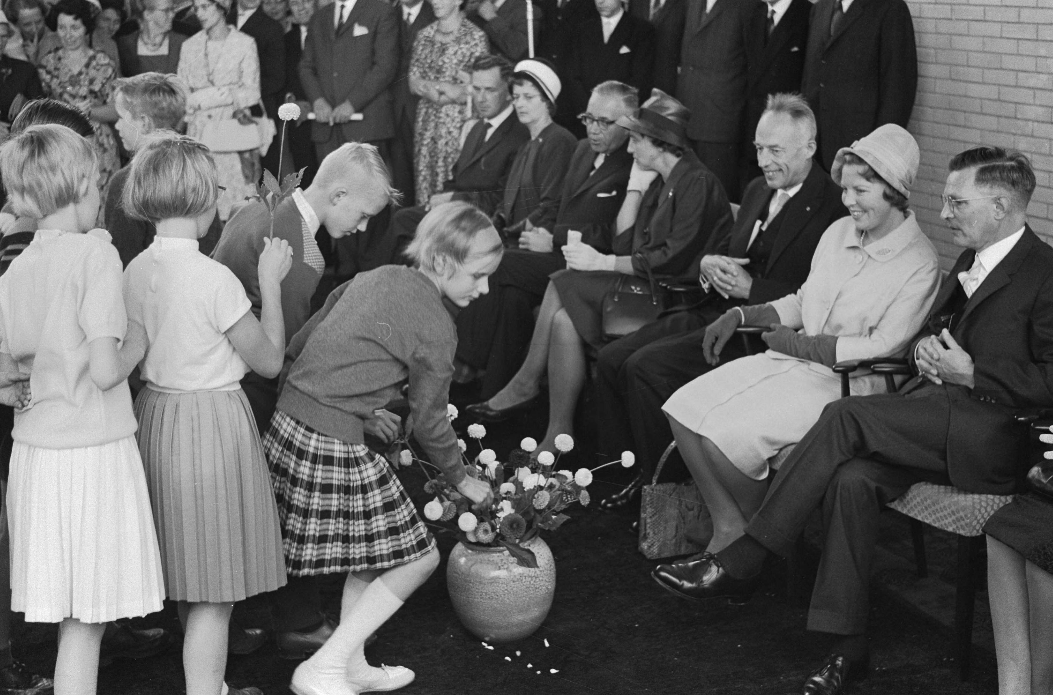 Fotocollectie Anefo — Prinses Beatrix opent Buitenschool in Leeuwarden. De prinses krijgt bloemen in de gymnastiekzaal. Rechts naast de prinses dr. E.H. Hijmersma, voorzitter van de Buitenschool. Links burgemeester A.A.M. van der Meulen — Foto: Pot, Harry / Anefo. Licentie: Set B: Rechtenvrij / Publiek Domein. Bron: Nationaal Archief. http://hdl.handle.net/10648/a9e262f4-d0b4-102d-bcf8-003048976d84