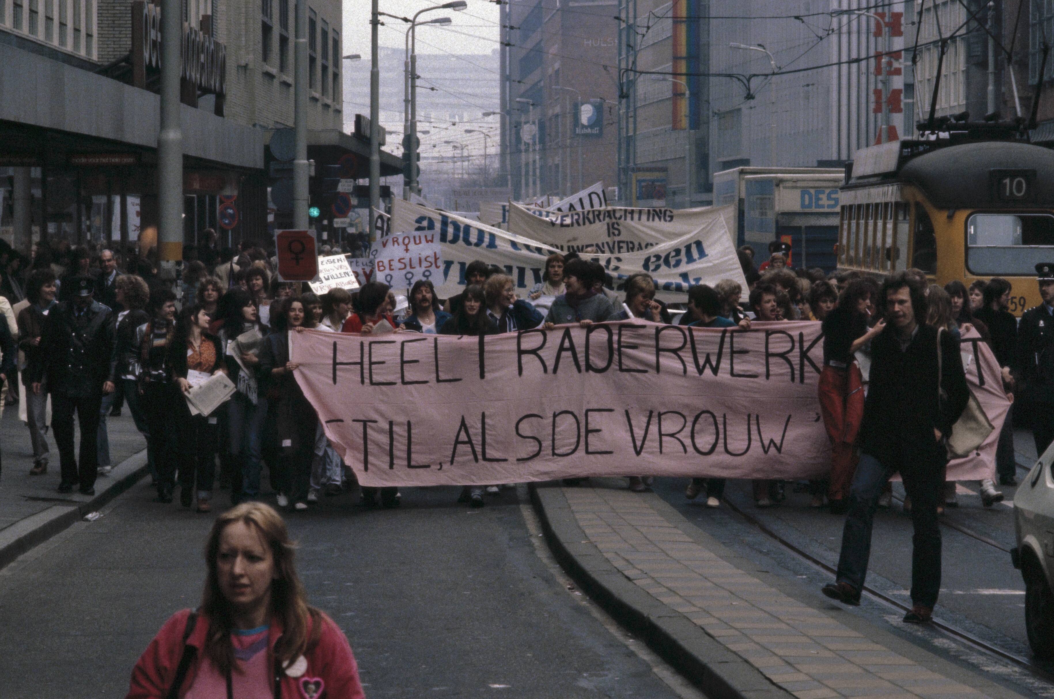 Fotocollectie Anefo — Landelijke vrouwenstakingsdag ( Den Haag ); demonstratie met borden en spandoeken onderweg in Den Haag — Foto: Dijk, Hans van / Anefo. Licentie: Set B: Rechtenvrij / Publiek Domein. Bron: Nationaal Archief. http://hdl.handle.net/10648/ad8a658c-d0b4-102d-bcf8-003048976d84