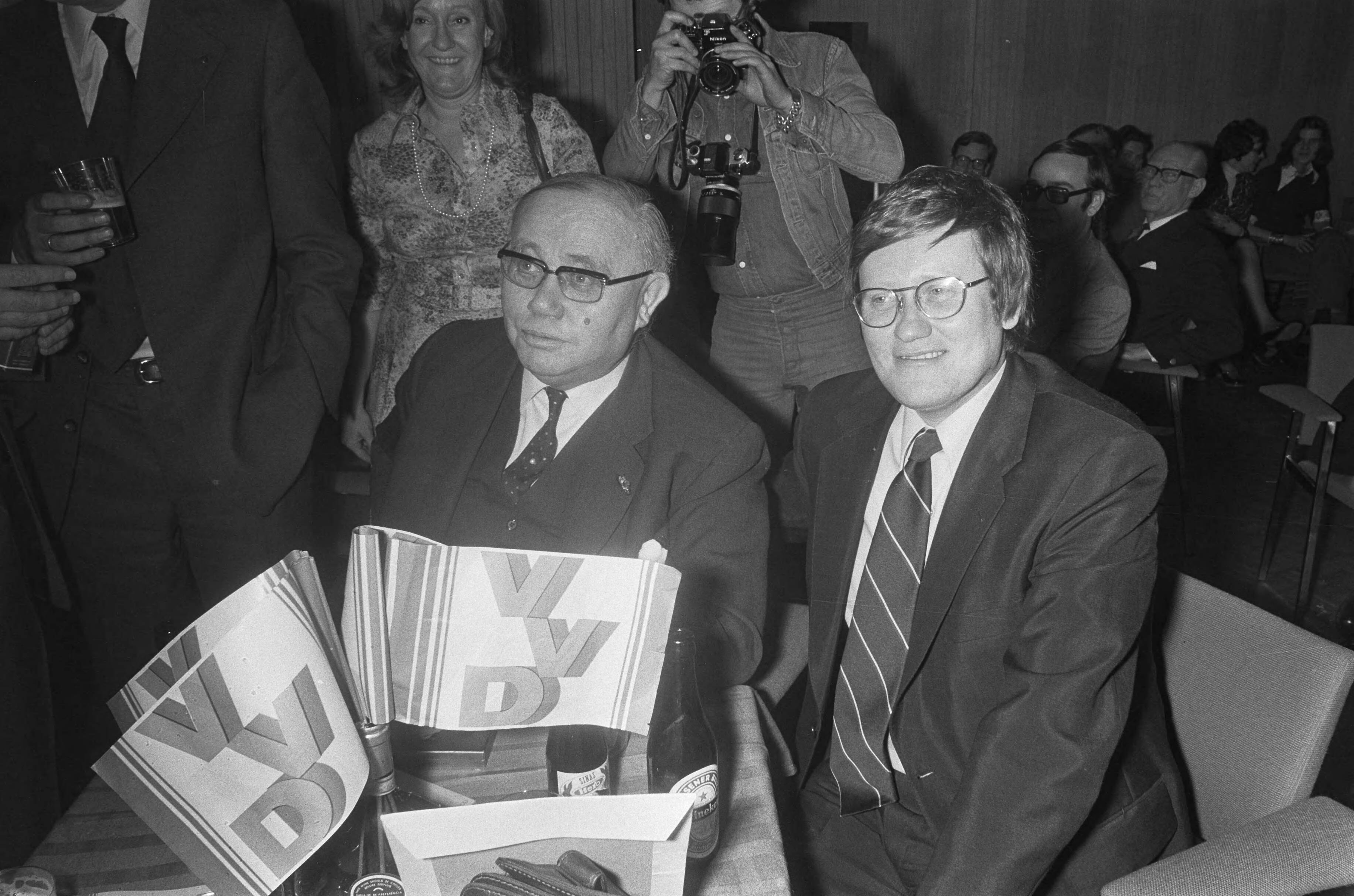 Fotocollectie Anefo — Hans Wiegel VVD in Den Haag tijdens de uitslagen in het Congresgebouw; Van Riel en Hans Wiegel — Foto: Peters, Hans / Anefo. Licentie: Set B: Rechtenvrij / Publiek Domein. Bron: Nationaal Archief. http://hdl.handle.net/10648/ac46d1f6-d0b4-102d-bcf8-003048976d84
