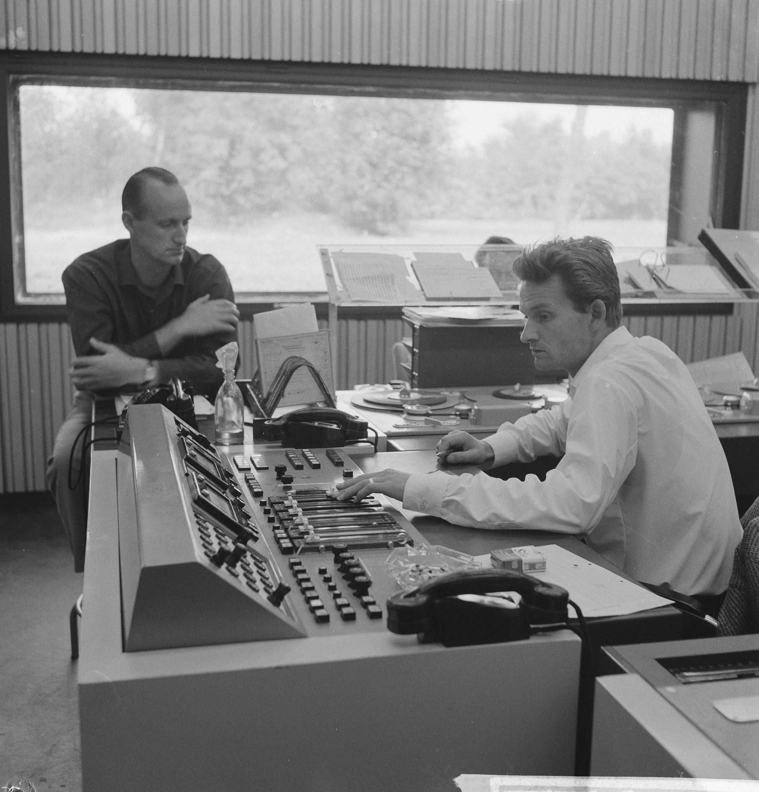 Fotocollectie Anefo — Nieuw gebouw voor Wereldomroep in Hilversum. Commentator beluistert opname — Foto: Koch, Eric / Anefo. Licentie: Set B: Rechtenvrij / Publiek Domein. Bron: Nationaal Archief. http://hdl.handle.net/10648/a9e3295a-d0b4-102d-bcf8-003048976d84