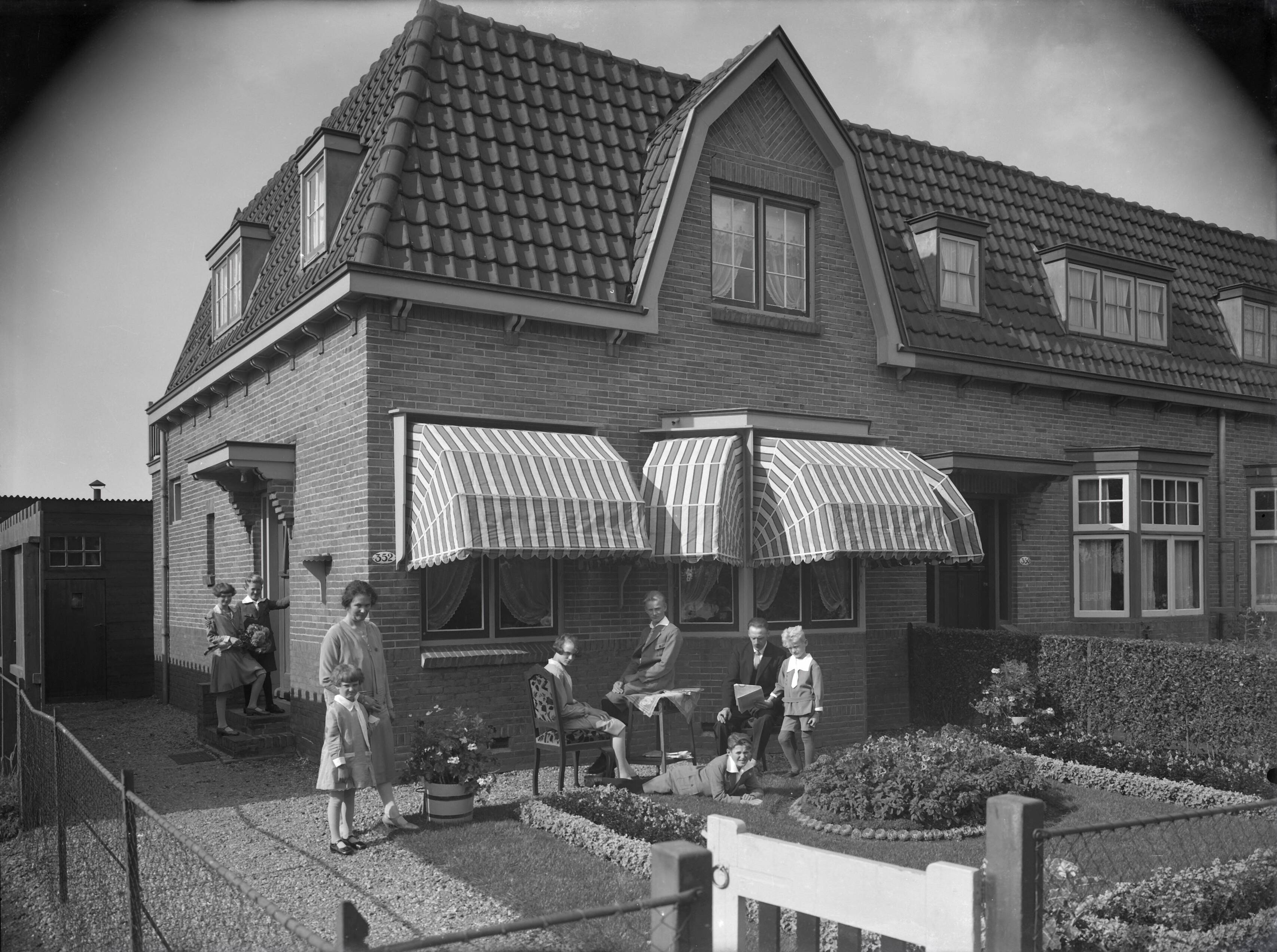 Berg, van den (BERG 050) — [Hoekwoning met huisnummer 352 met gezin in de voortuin] — Foto: Berg, Th.C.J. van den / Spaarnestad Photo (05887). Licentie: Set B: Rechtenvrij / Publiek Domein. Bron: Nationaal Archief. http://hdl.handle.net/10648/35429da6-760d-a382-e063-6df0900a6686